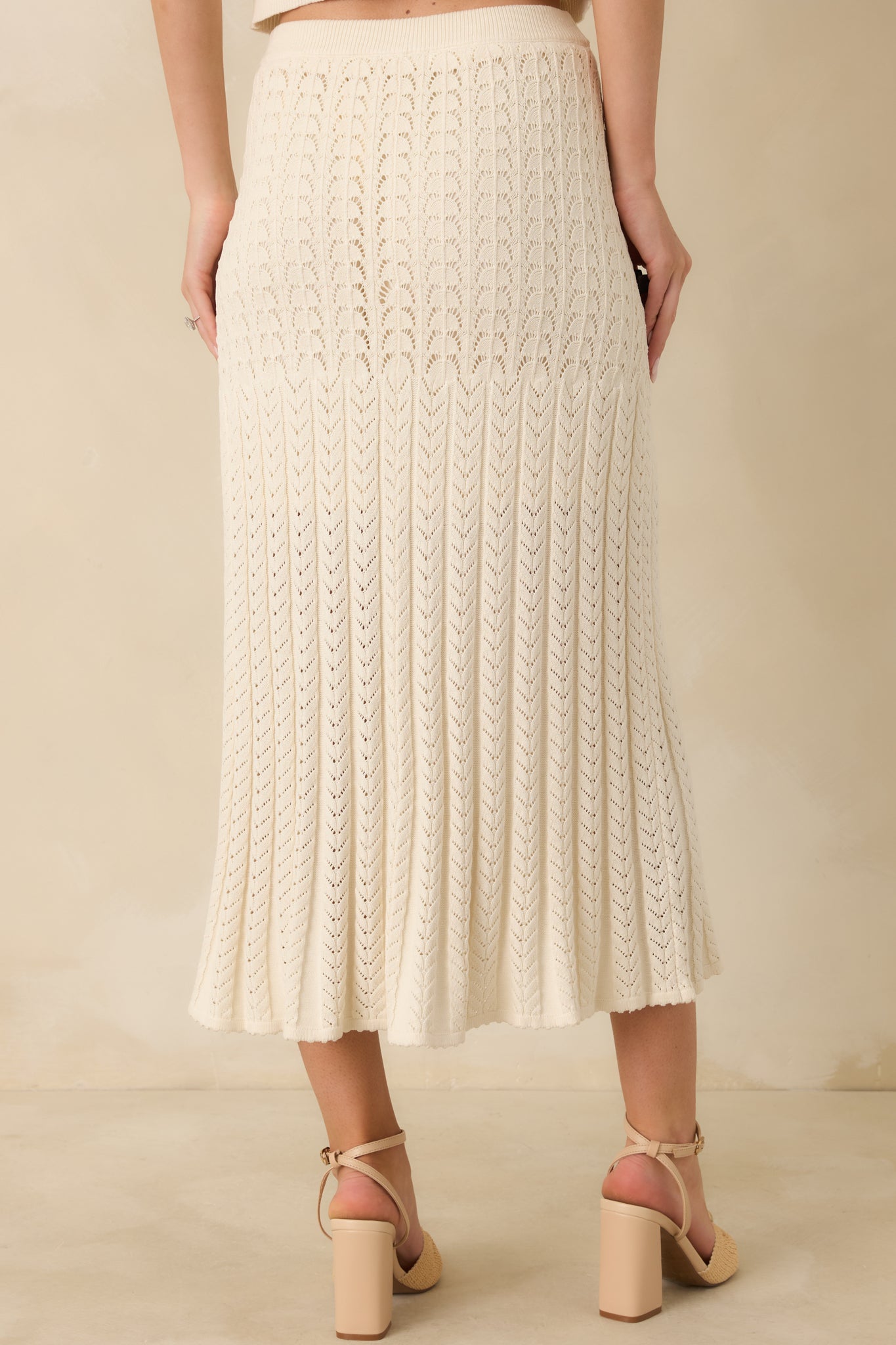 Rear view of the ivory sweater skirt highlighting the elastic waistband and streamlined midi silhouette.