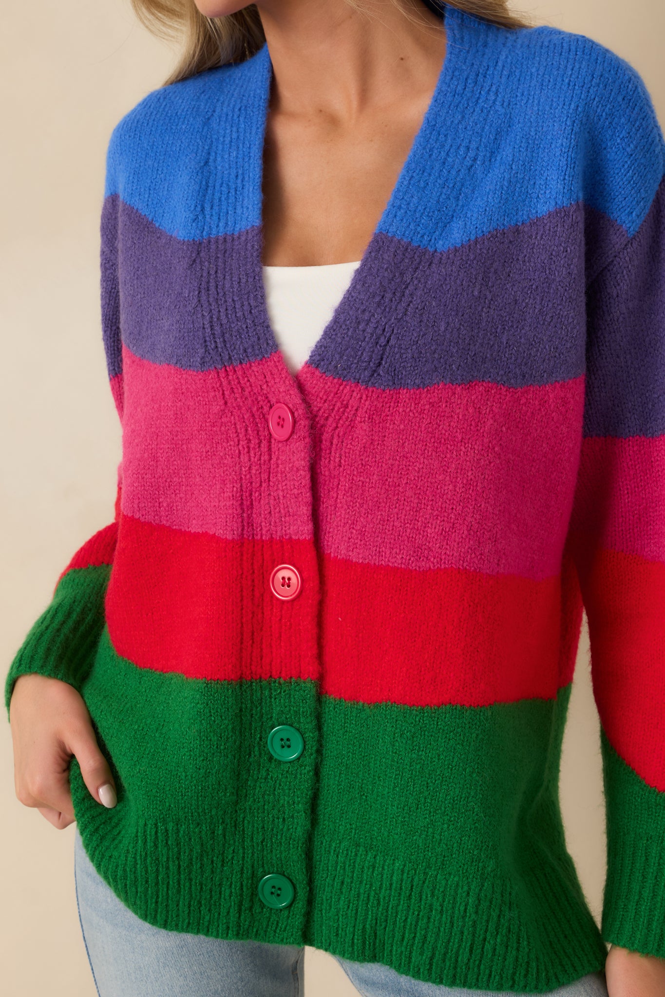 Close-up of the multi colorblock knit fabric showing texture, ribbed edges, and button details.