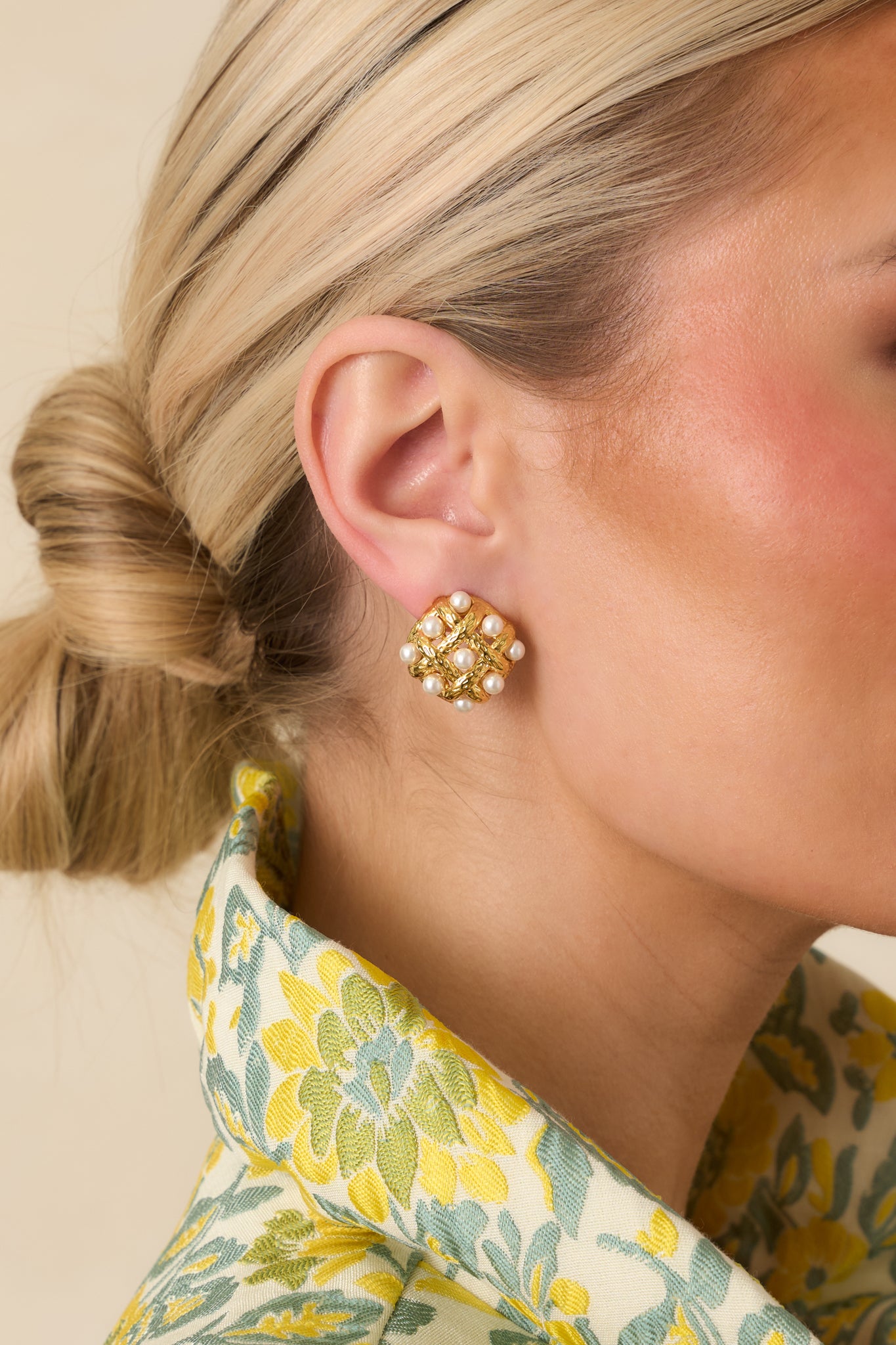 Gold earrings with twisted woven design and pearl embellishments on secure post backings.