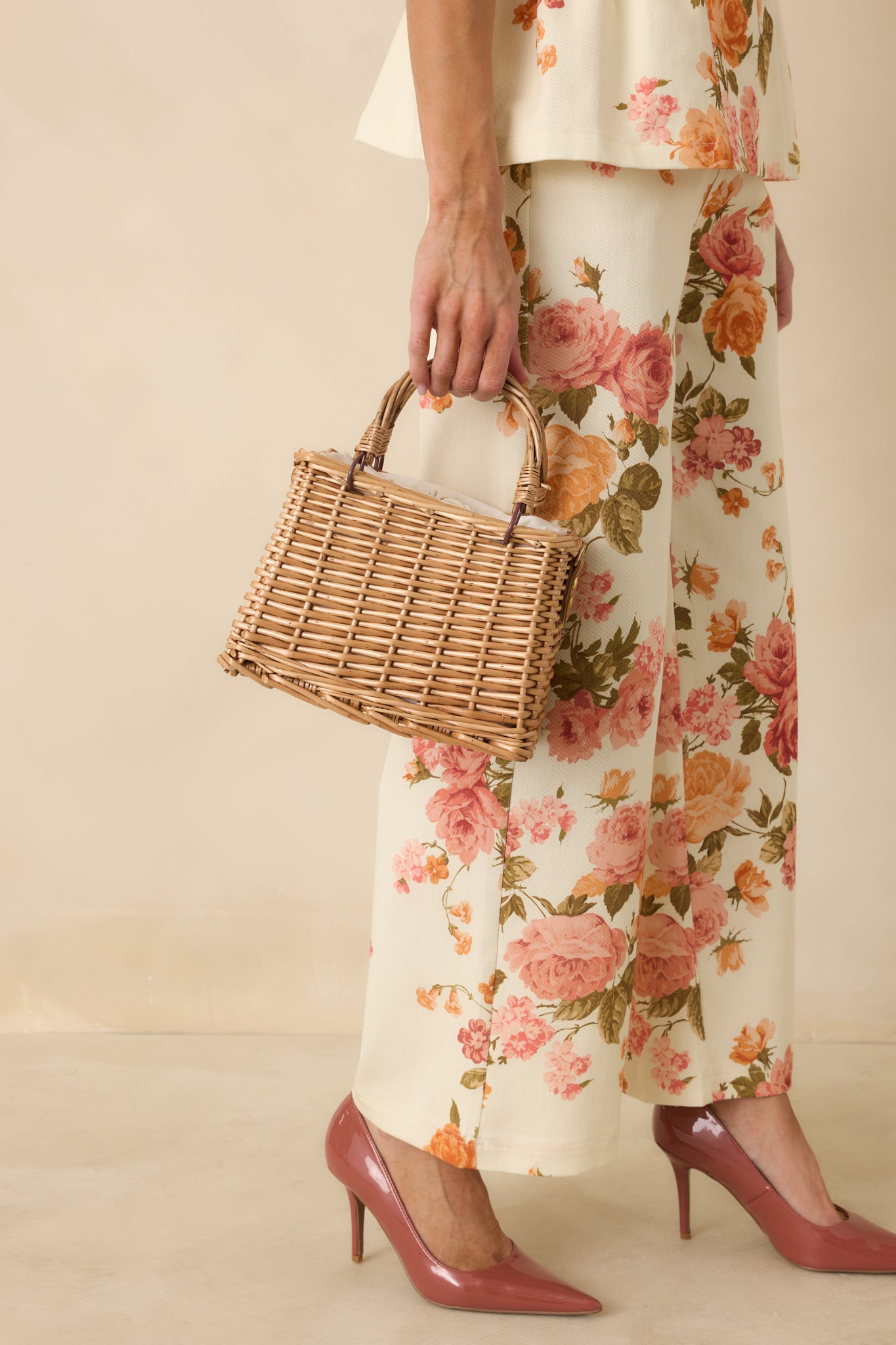 Wicker-style handbag featuring a structured woven body, drawstring closure, sturdy handles, and a detachable faux pearl strap for added charm.