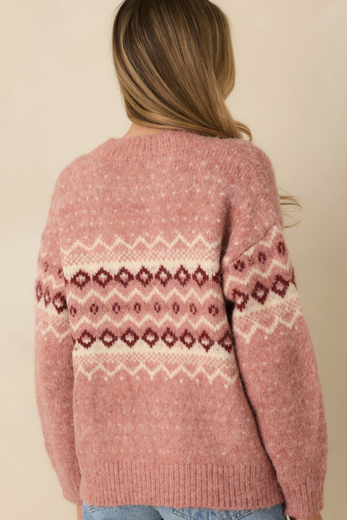 Rear view of rose pink cardigan highlighting long sleeves, ribbed hem, and smooth back knit finish.