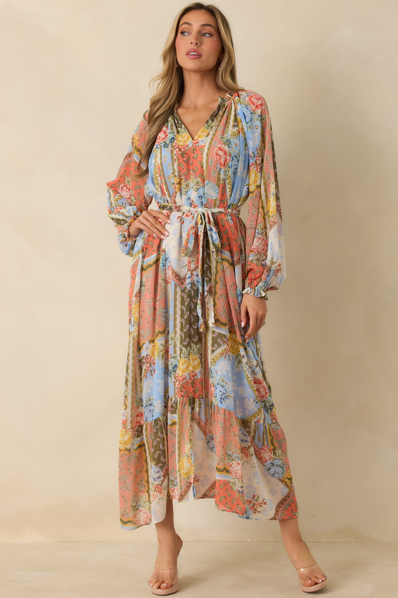 Flowing multi floral dress with self-tie belt, ruffled neckline, and airy tiered hem.