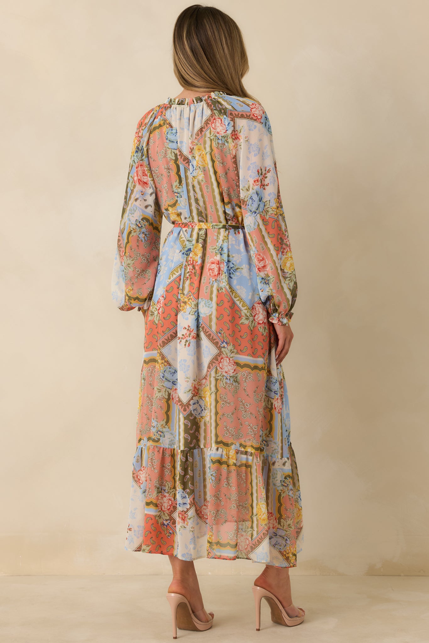 Rear view of floral dress highlighting elastic cuffs, belt loops, and ruffled tiered skirt.