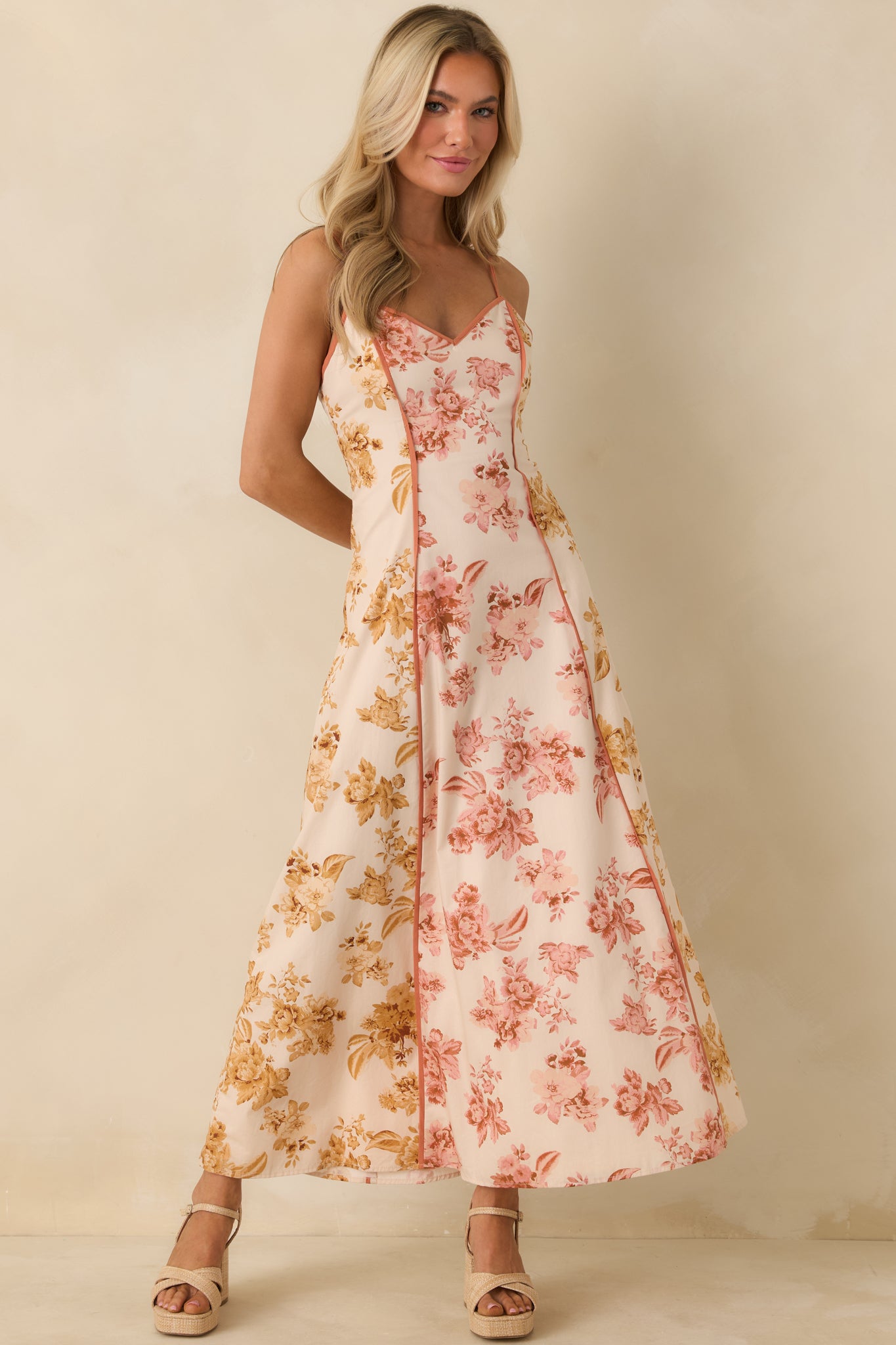 Floral maxi dress with V-neck design, adjustable straps, and contrasting clay trim panels.