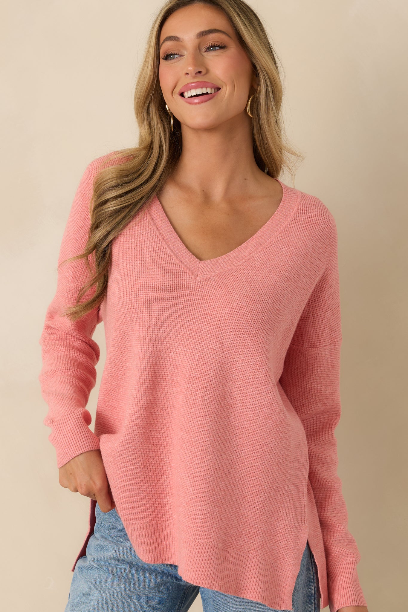 Cropped view of rose sweater highlighting V-neckline, ribbed cuffs, and soft lightweight knit fabric.