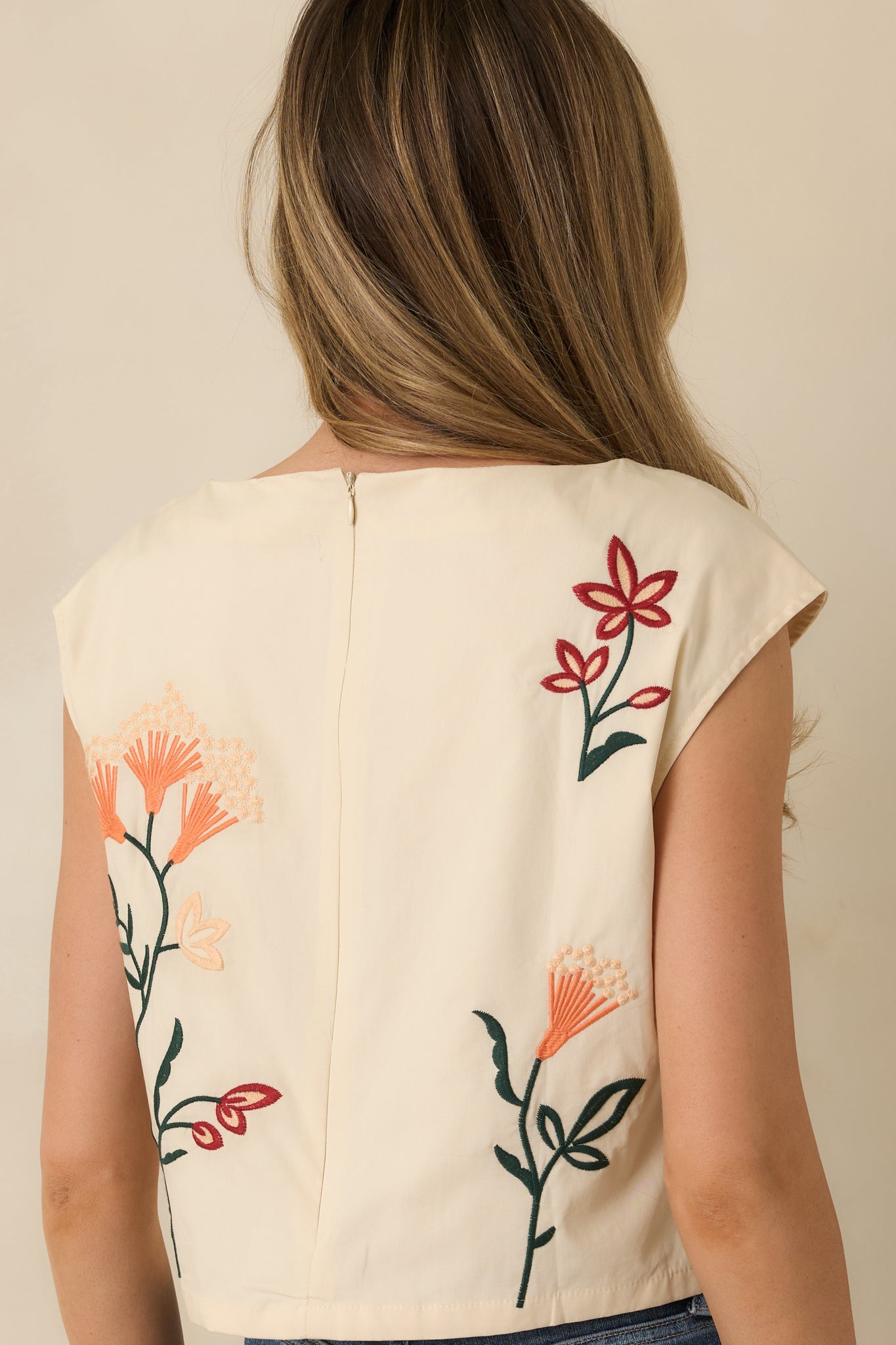 Rear view of the natural top showing the clean straight hem, structured silhouette, and lined fabric.