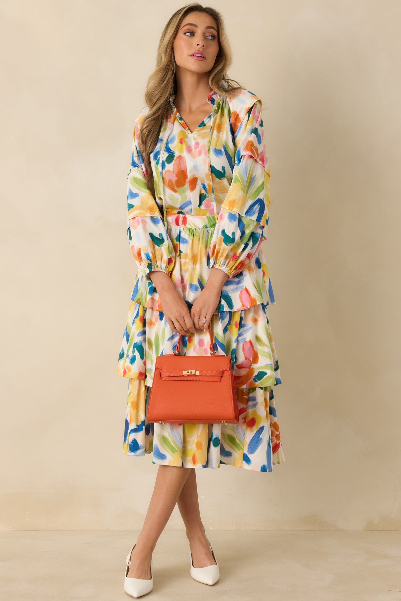 Flowing cotton midi skirt with a tiered design, high-rise fit, and allover multicolor floral pattern.