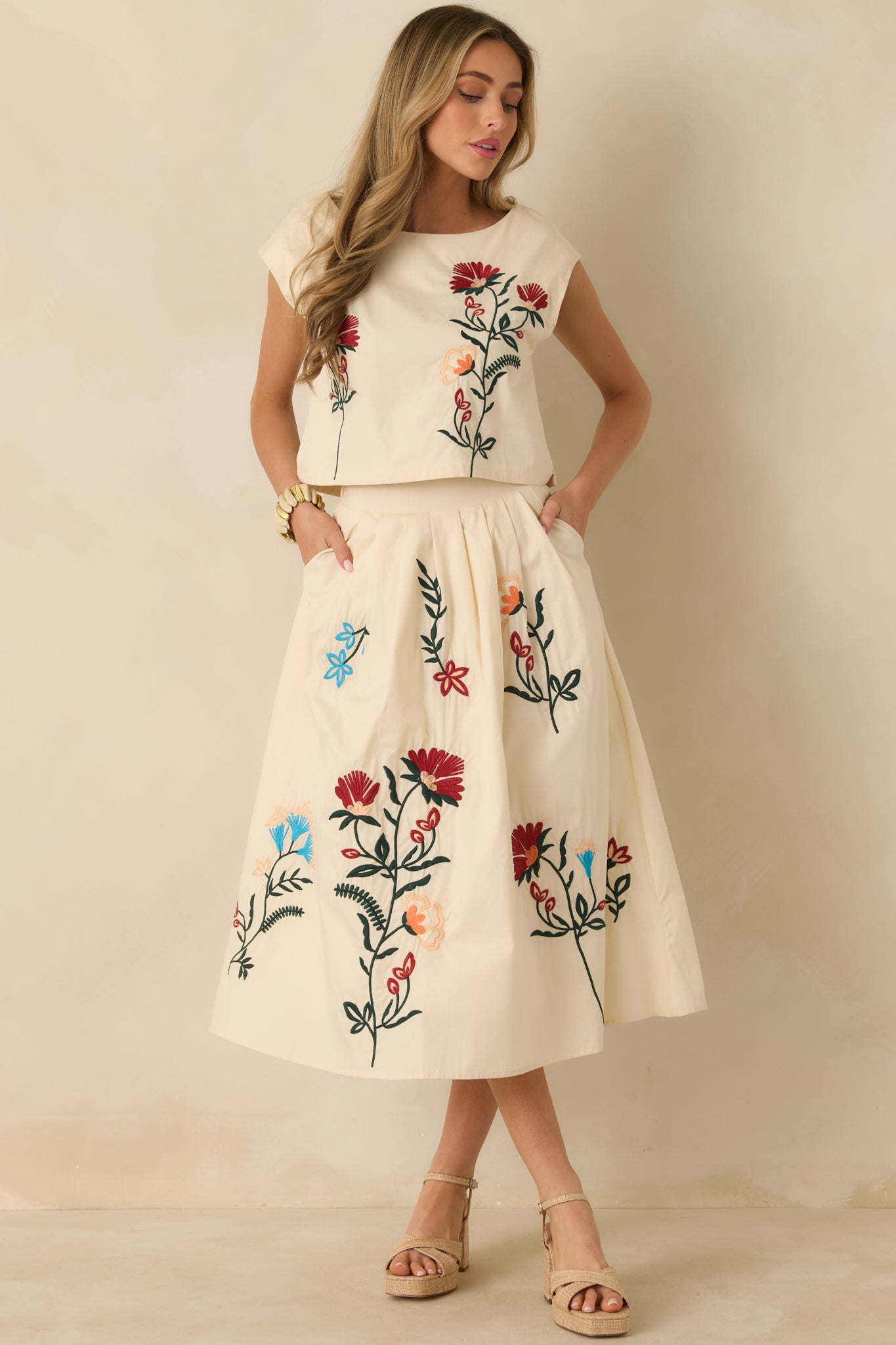 Lightweight top in a natural hue with embroidered front design, cap sleeves, and lined construction for comfort.