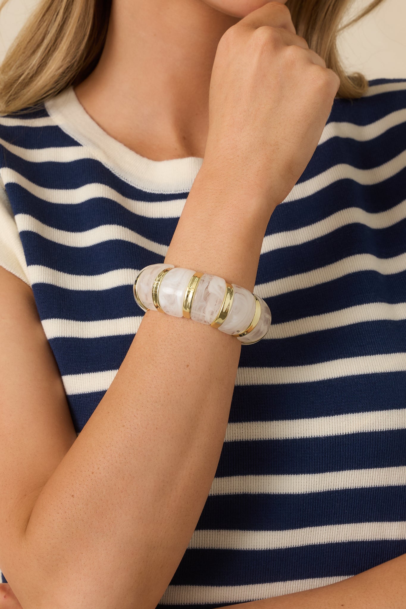 Close-up of the bracelet detailing the smooth, rounded gold settings and glossy finish along the stretch band.