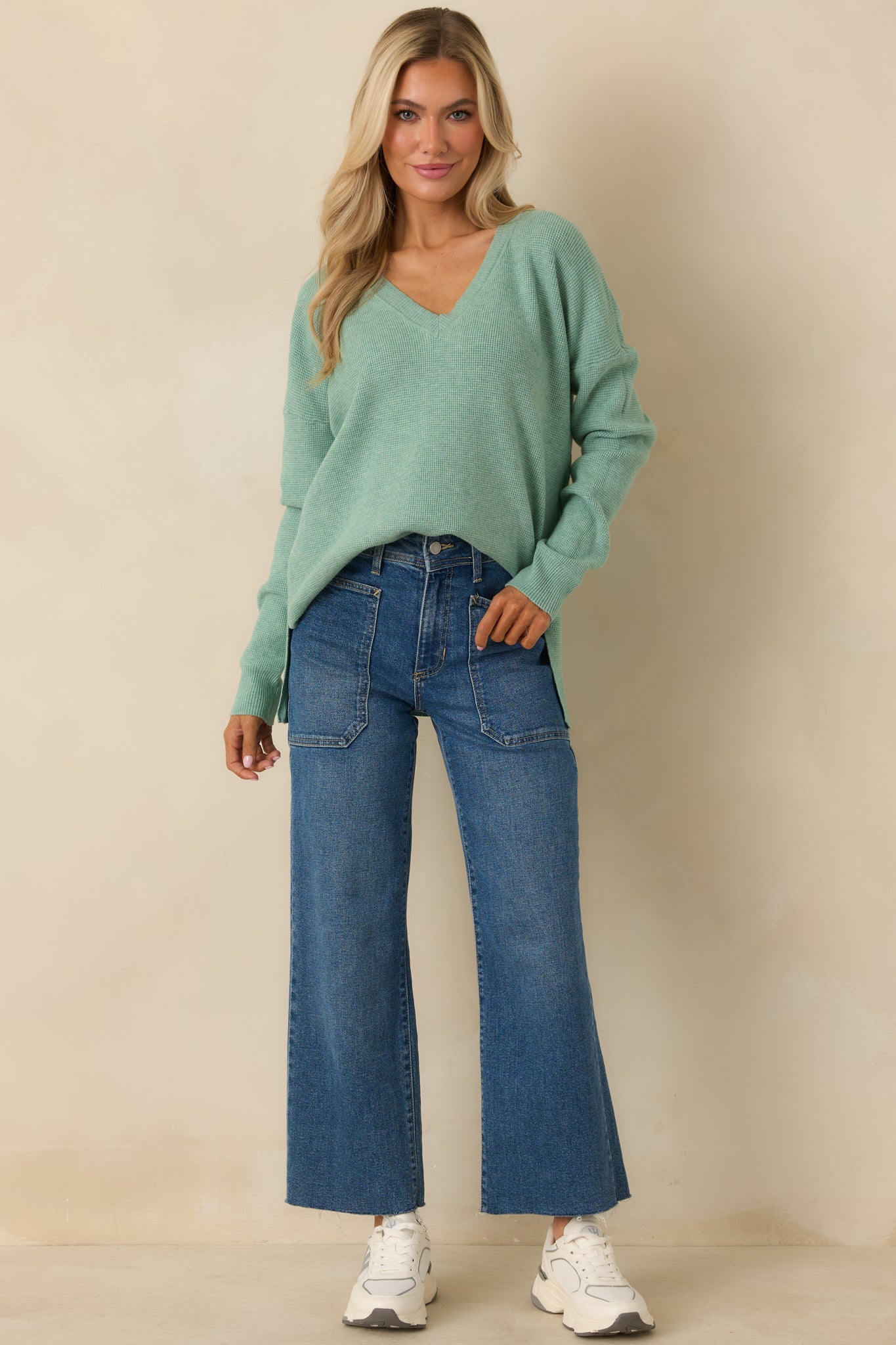 Light green sweater with a V-neckline, long sleeves, and a relaxed fit.