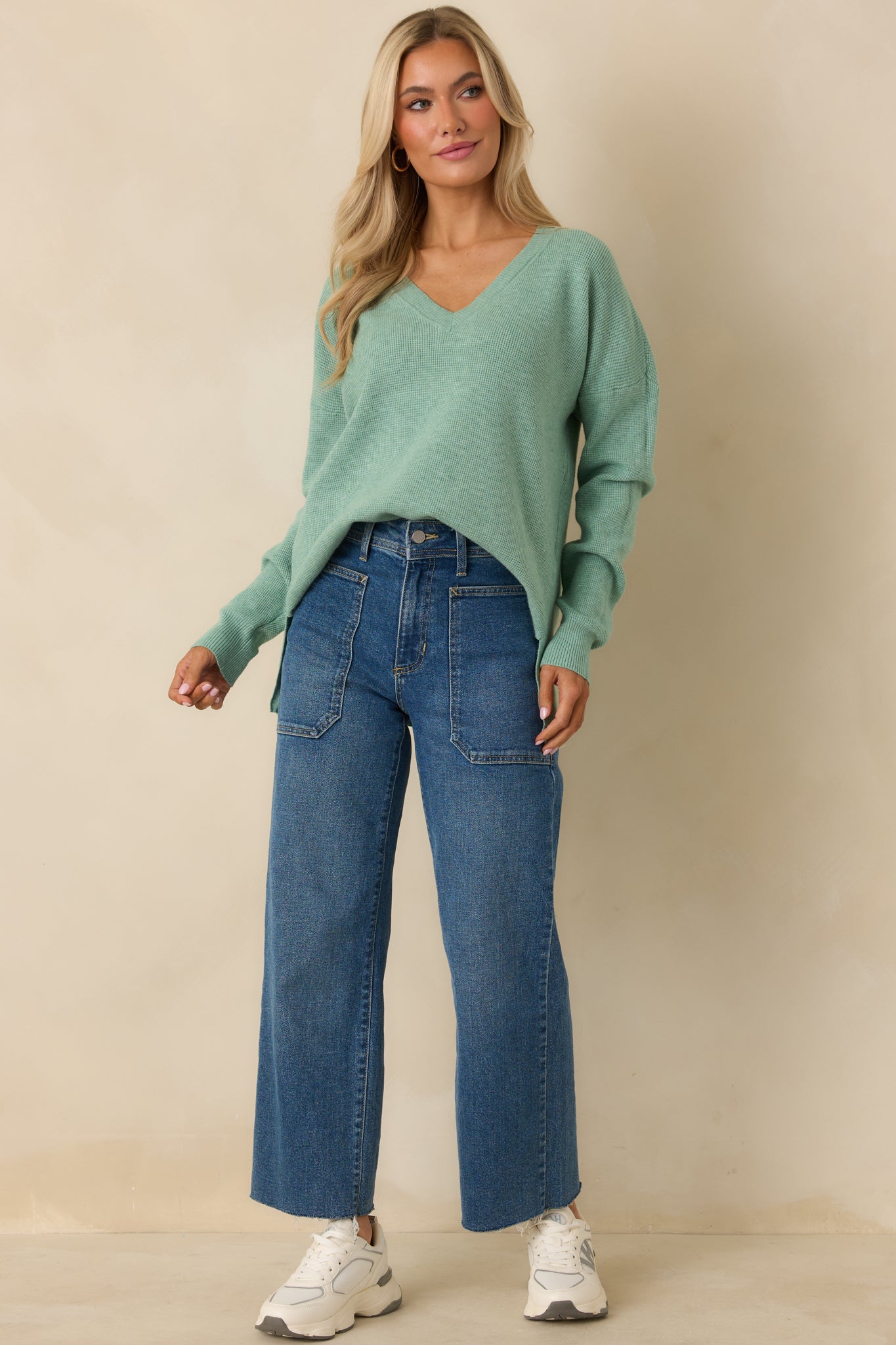Relaxed-fit light green sweater with long sleeves and a subtly split hem for movement.