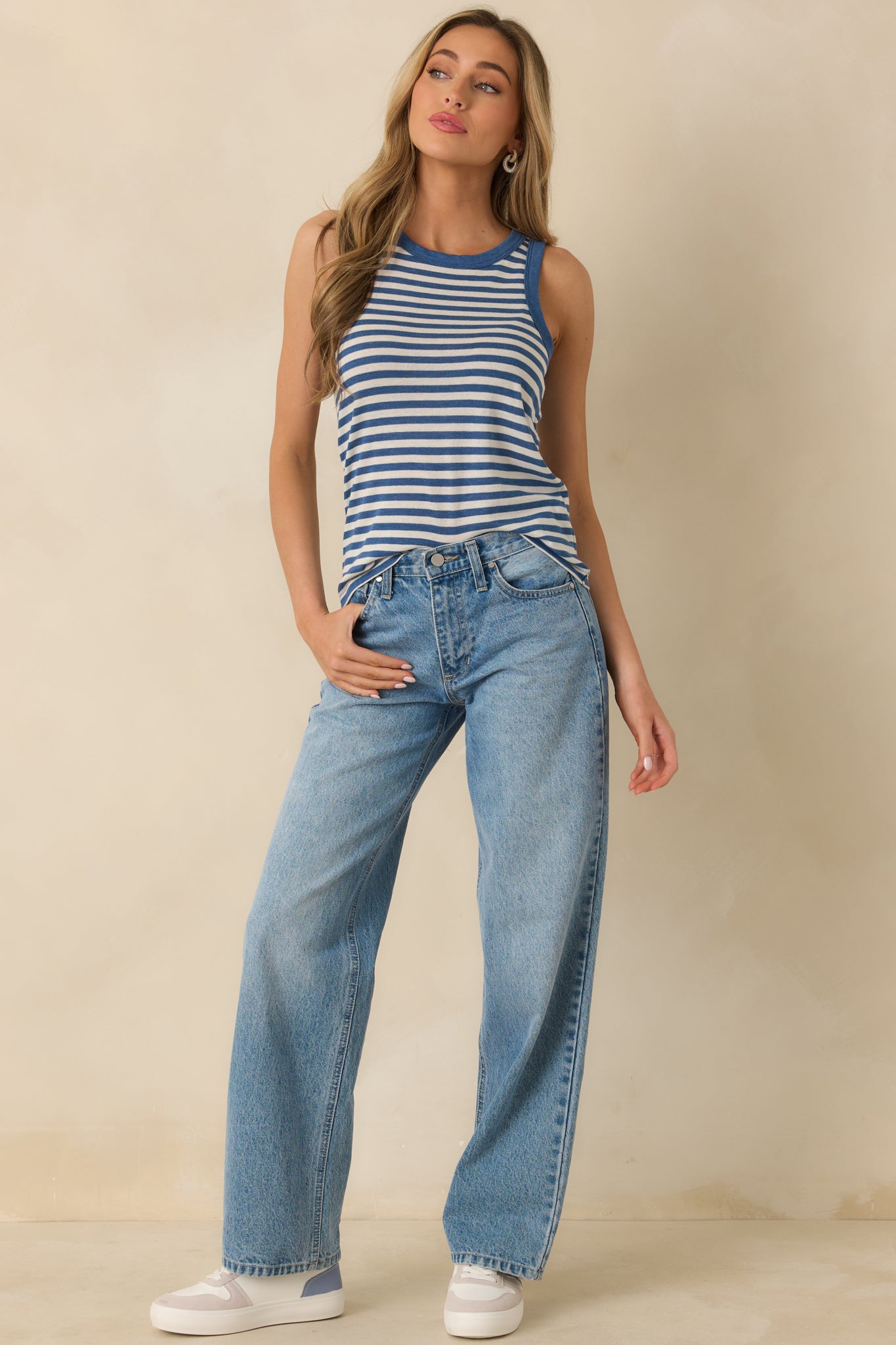 Front view of a blue striped tank top with a scoop neckline, sleeveless silhouette, and soft, lightweight knit fabric.