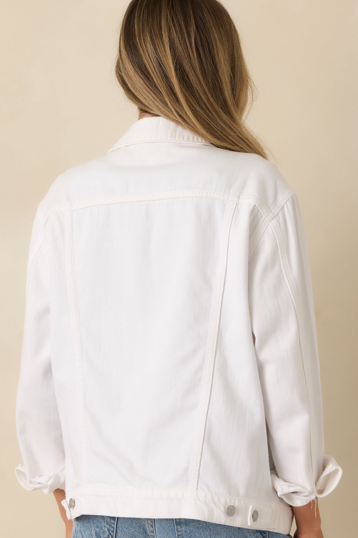 Back view of the white denim jacket highlighting the clean back panel and structured fit.