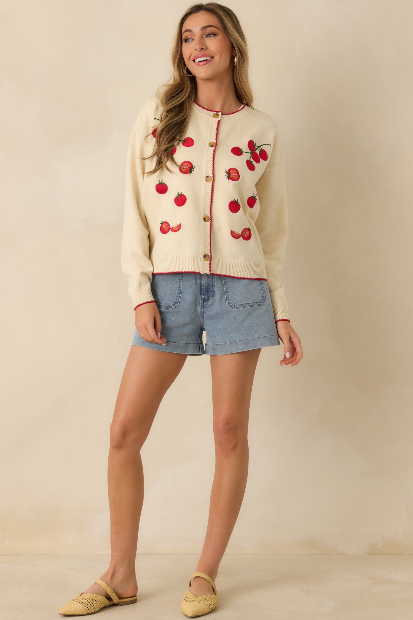 Relaxed-fit cardigan featuring contrast red trim along the button placket, cuffs, hem, and neckline.