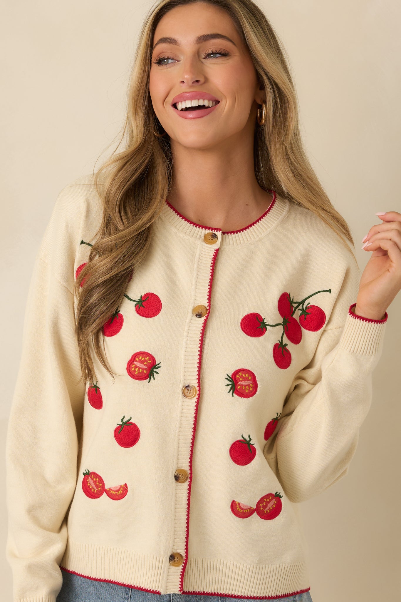 Closer view highlighting the contrast red trim along the button placket, cuffs, and hem.