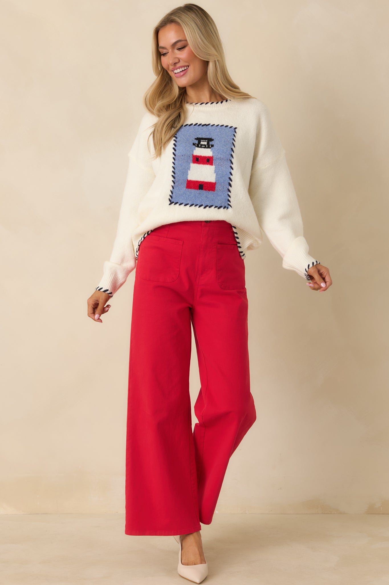 Ivory multi knit sweater highlighting the lighthouse graphic, crew neckline, long sleeves, and whipstitch detailing along the hem and edges.