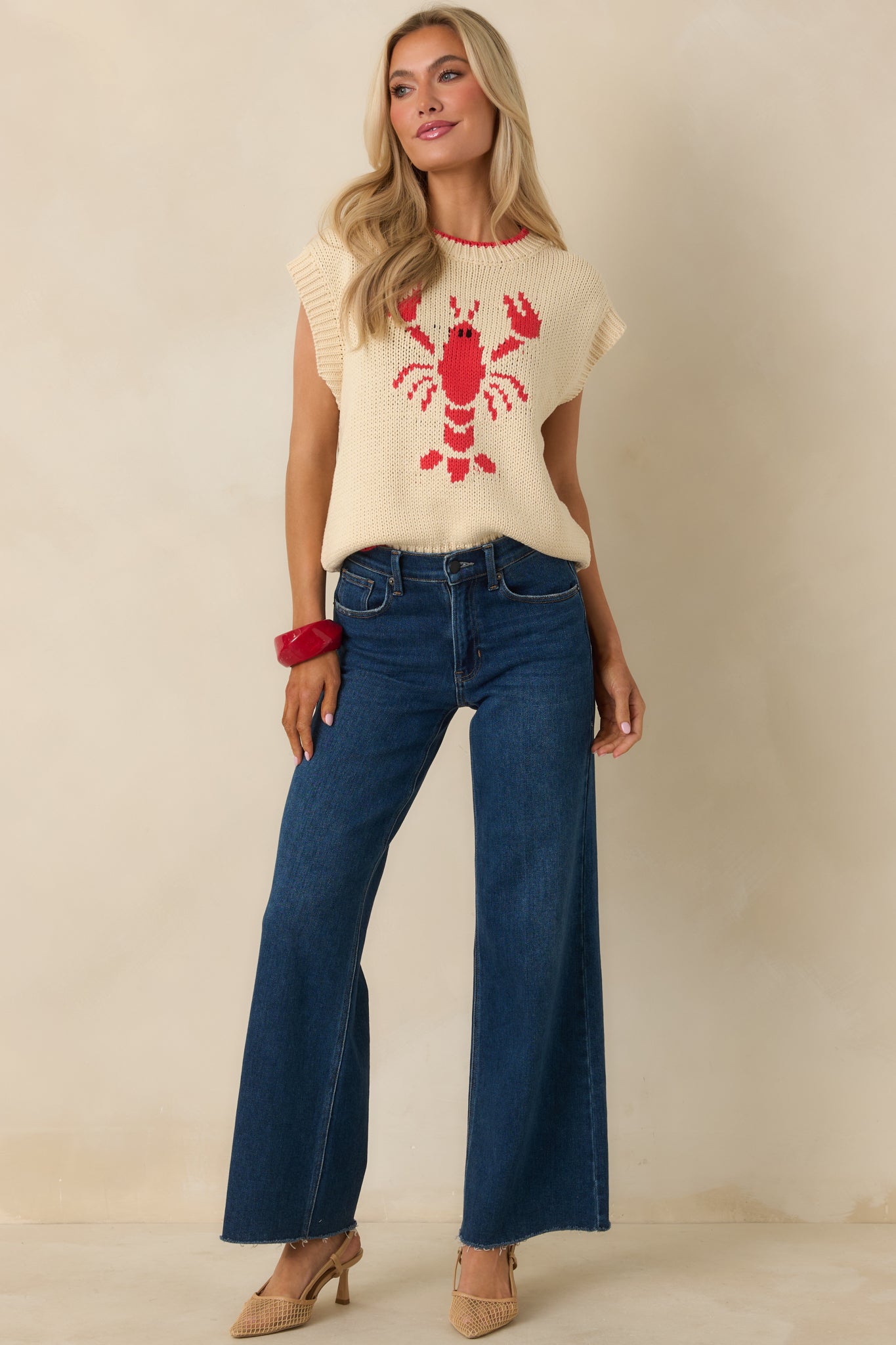 Straight-on front angle showing the sleeveless silhouette and comfortable layering fit of the ivory sweater.