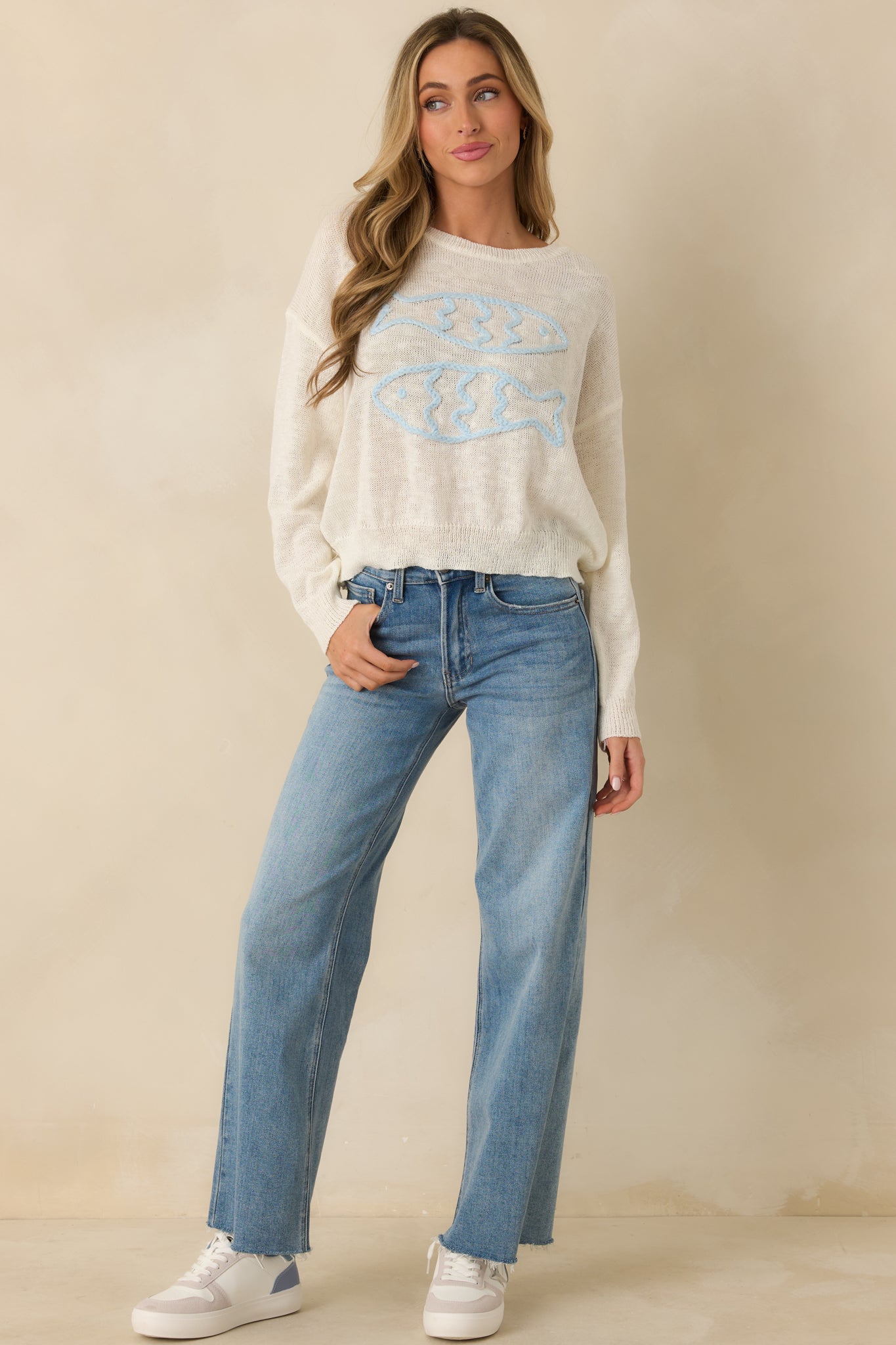 Ivory knit sweater with long sleeves and subtle coastal-inspired embroidery, full front view.
