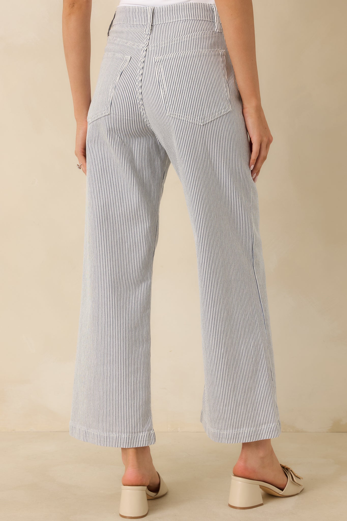 Back view of navy stripe denim jeans highlighting the functional rear patch pockets, high-rise waist, and wide leg silhouette.