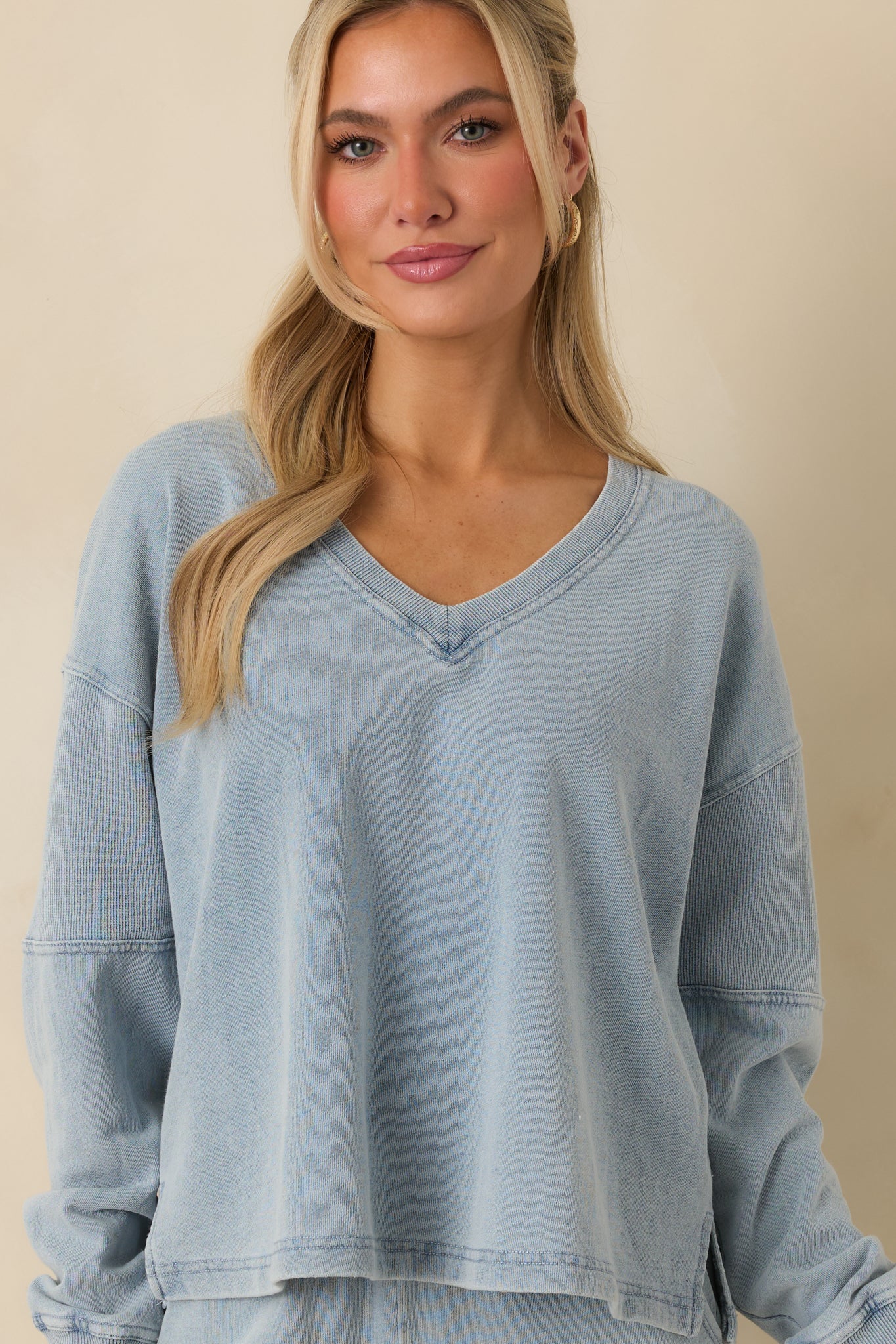 Indigo sweatshirt emphasizing ribbed hem and textured soft-washed denim look.