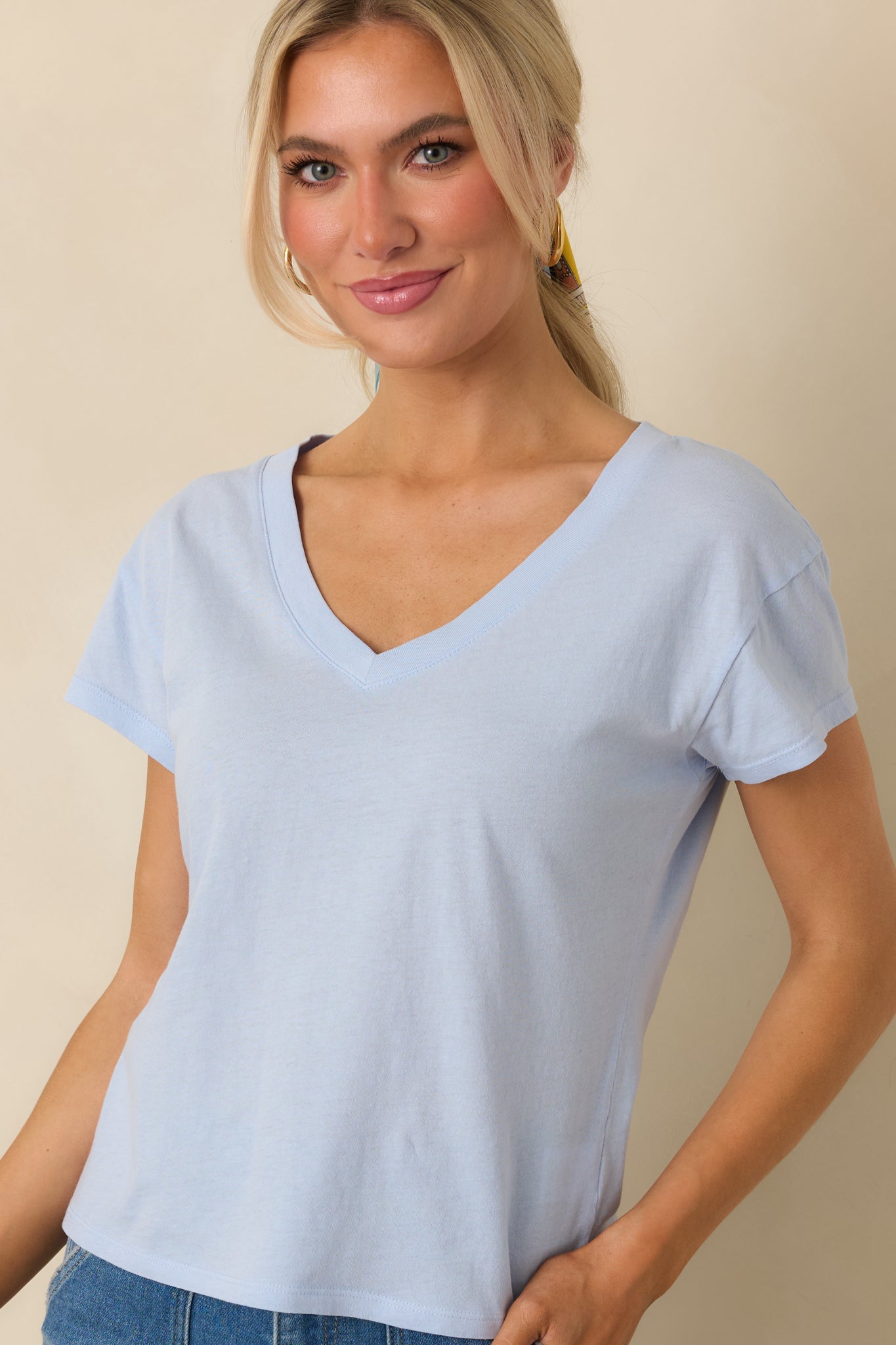 Closer view of the V-neckline and soft cotton jersey texture in light blue.