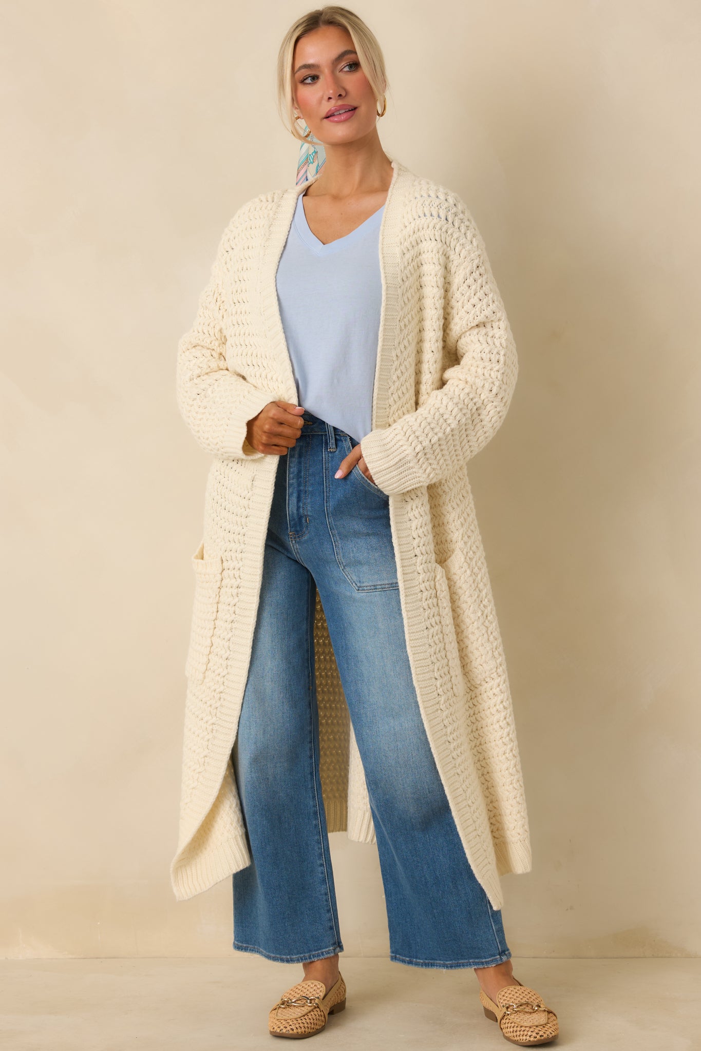 Cream knit duster cardigan with a longline shape, open front, and chunky textured knit.