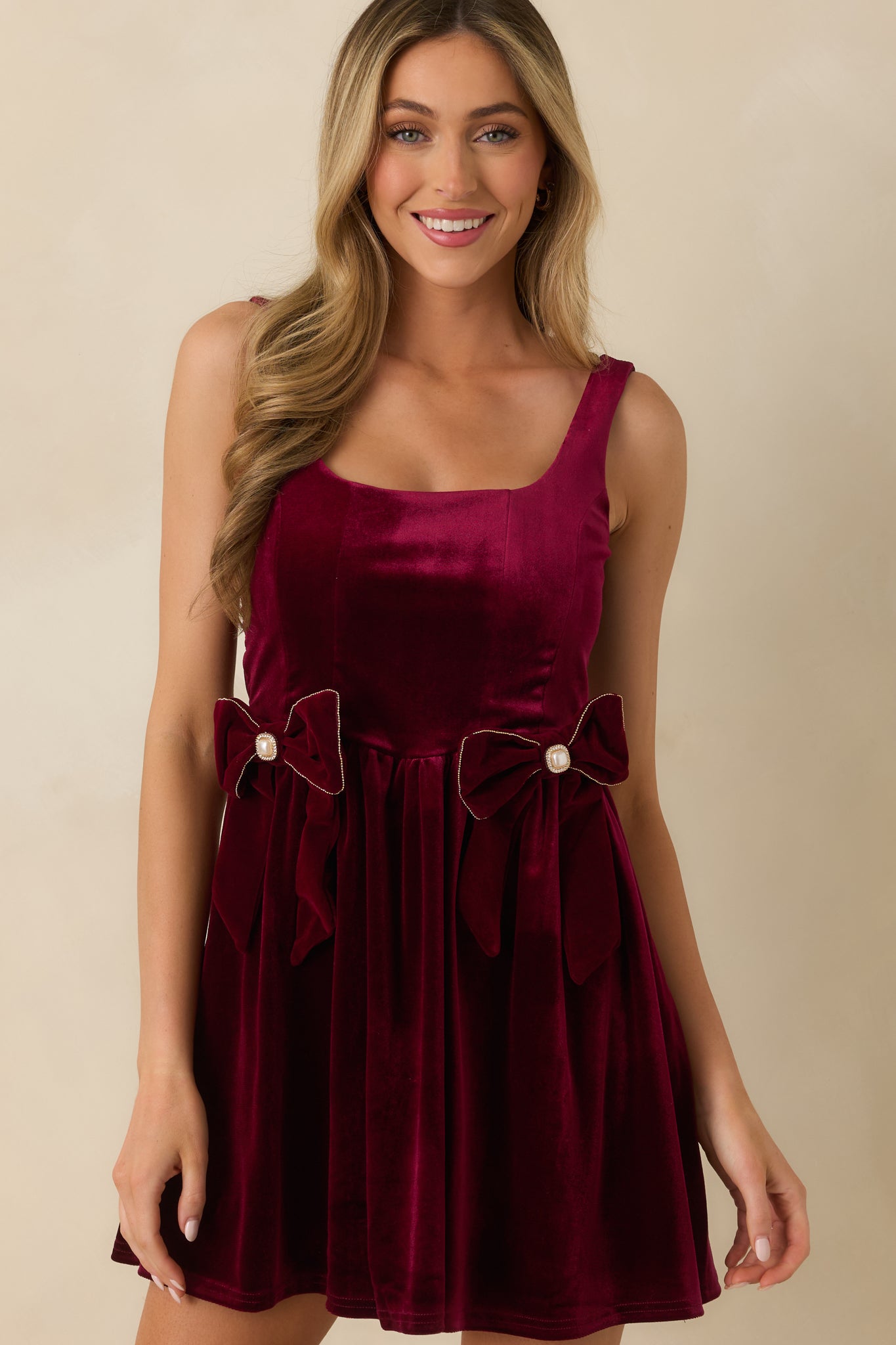 Cropped shot showing the smooth velvet texture, square neckline, and wide shoulder straps of the burgundy mini dress.