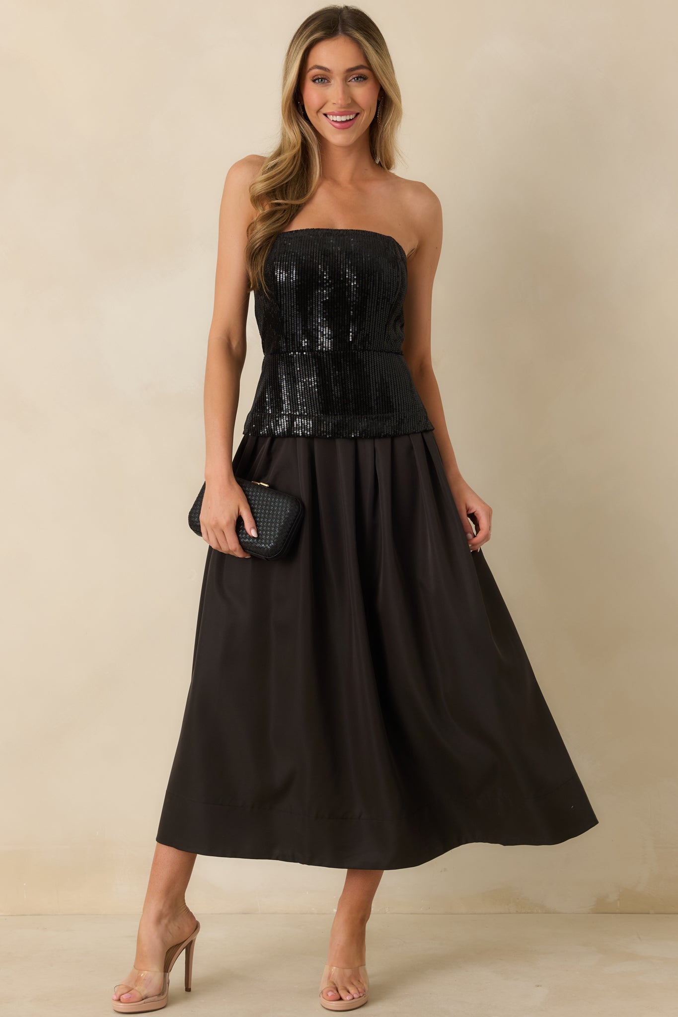Midi dress in black showcasing a strapless sequined bodice with boning support and a full pleated skirt for a dramatic fit-and-flare look.