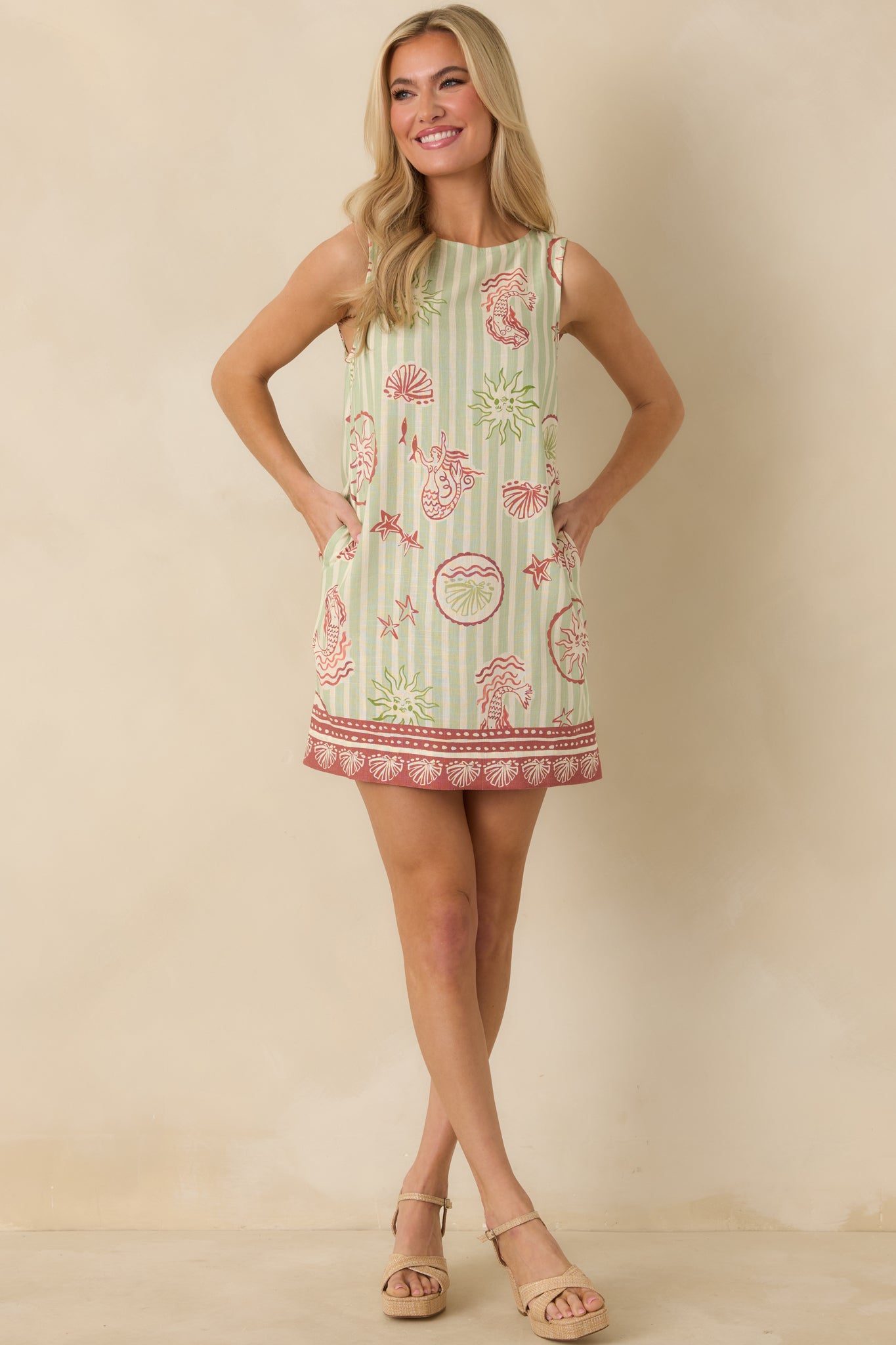 Green stripe mini dress with a relaxed shift silhouette and allover pink mermaid-inspired print.