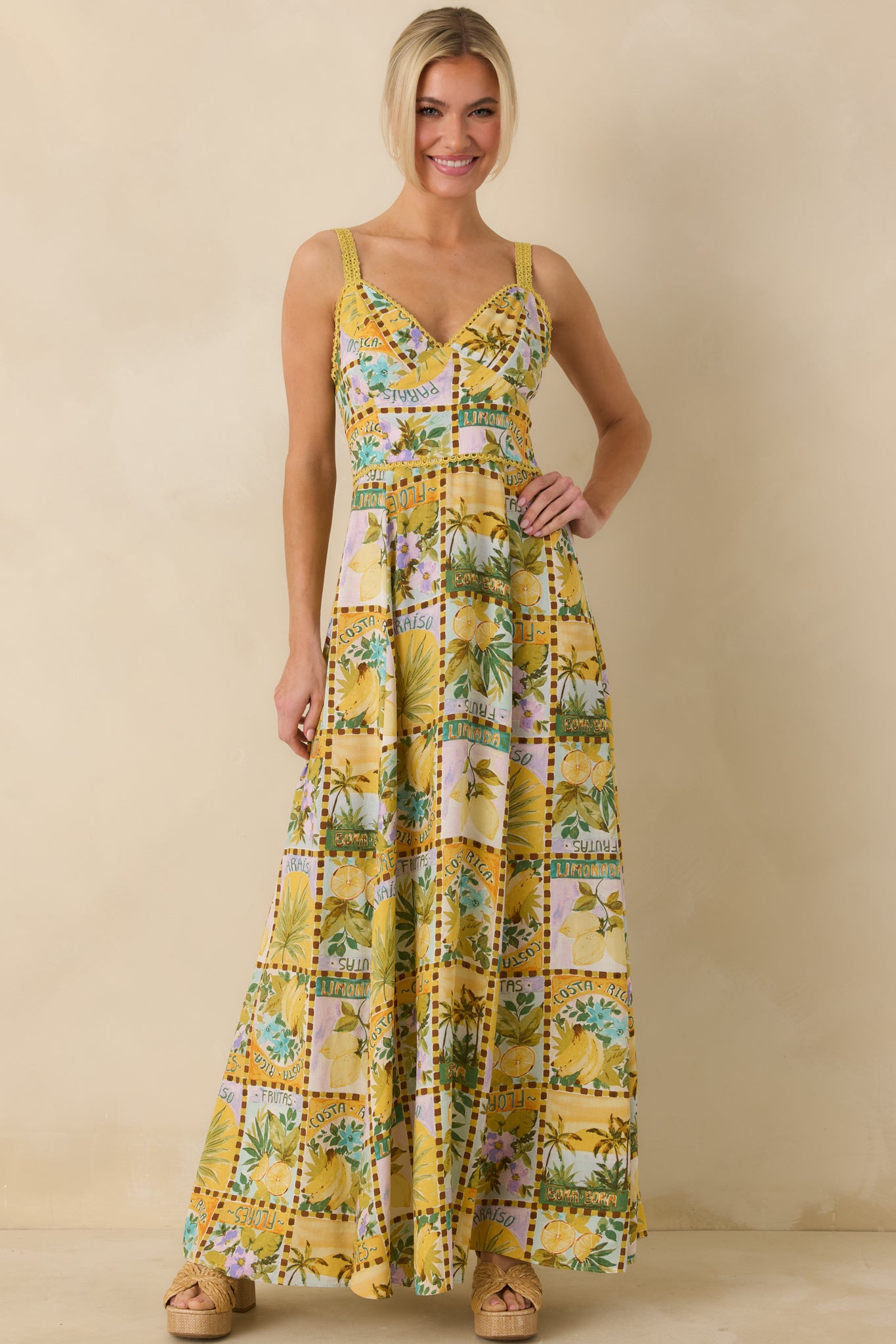 Tropical print yellow maxi dress featuring adjustable straps and scallop trim detail.