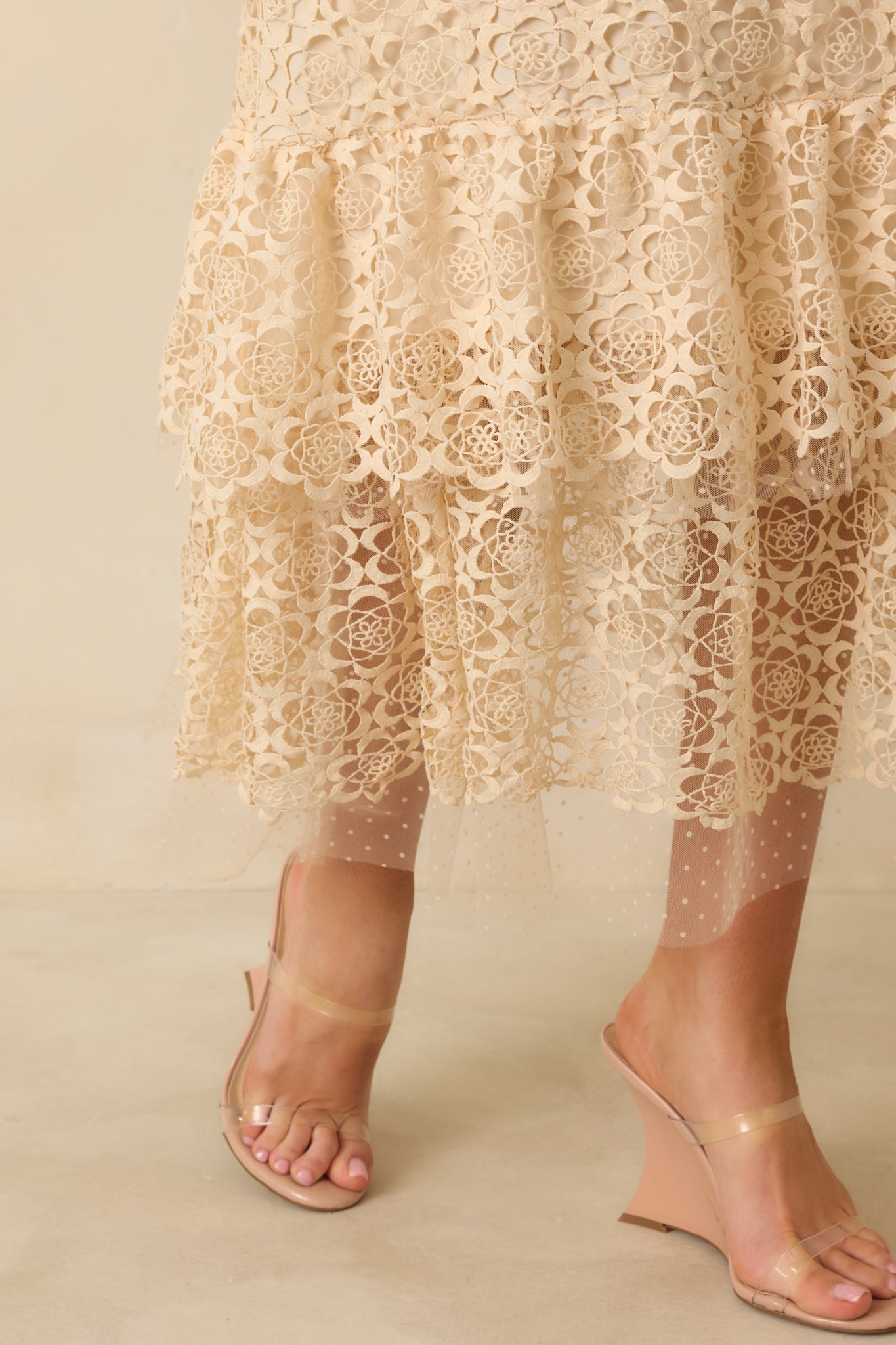 Close-up detail of lace ruffle trim and intricate embroidered pattern along the dress.
