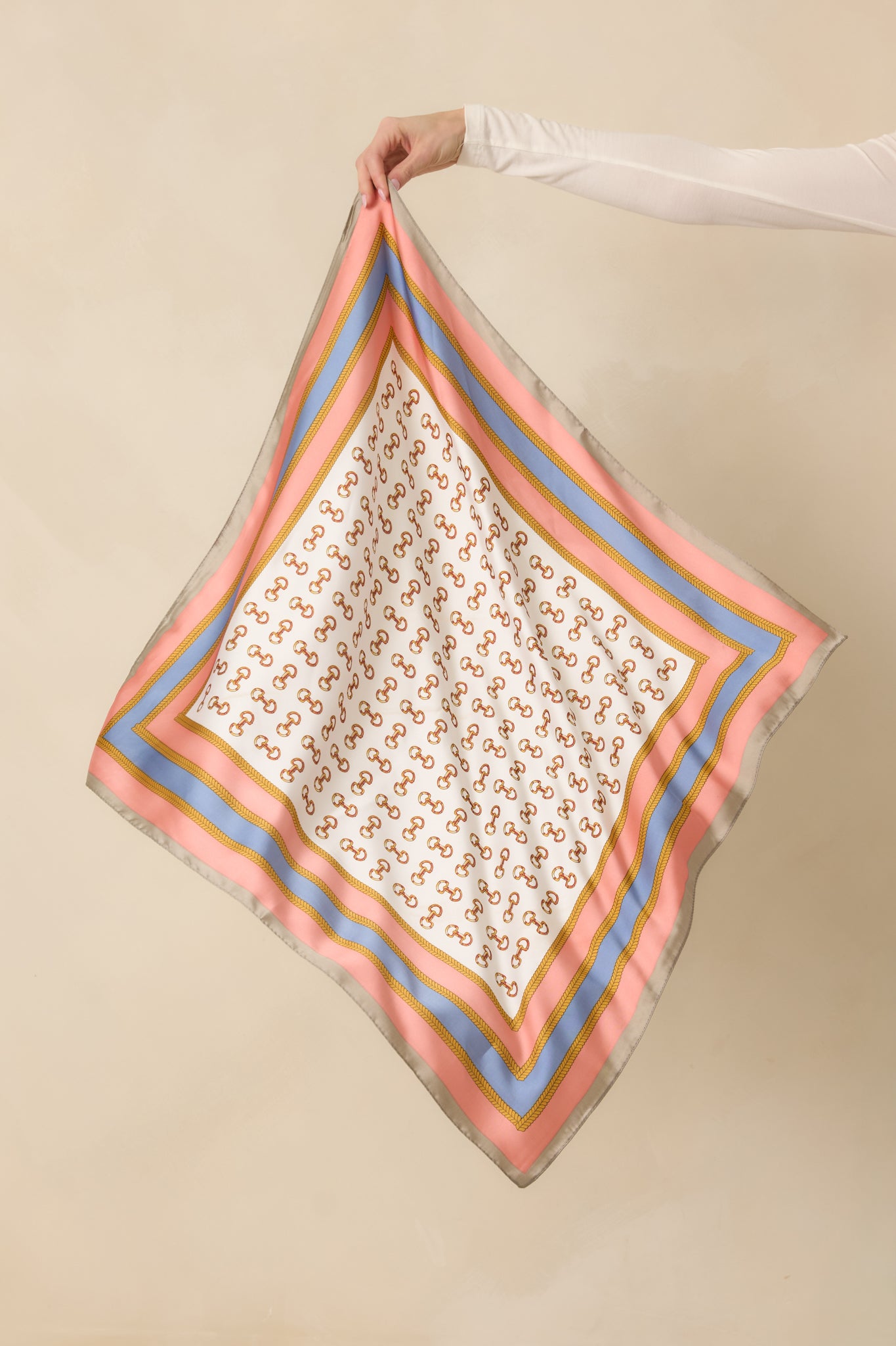 Square pink scarf with gold snaffle bit pattern and pink-gold chain border.