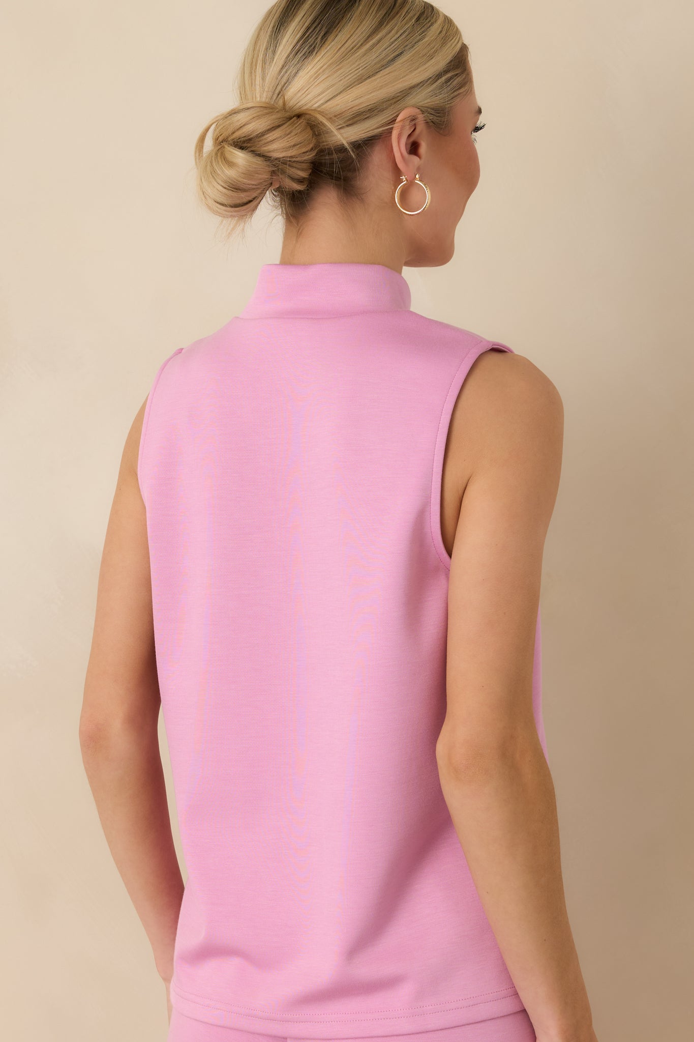 Pink sleeveless tank top displaying the relaxed silhouette from the rear with a smooth, clean finish.