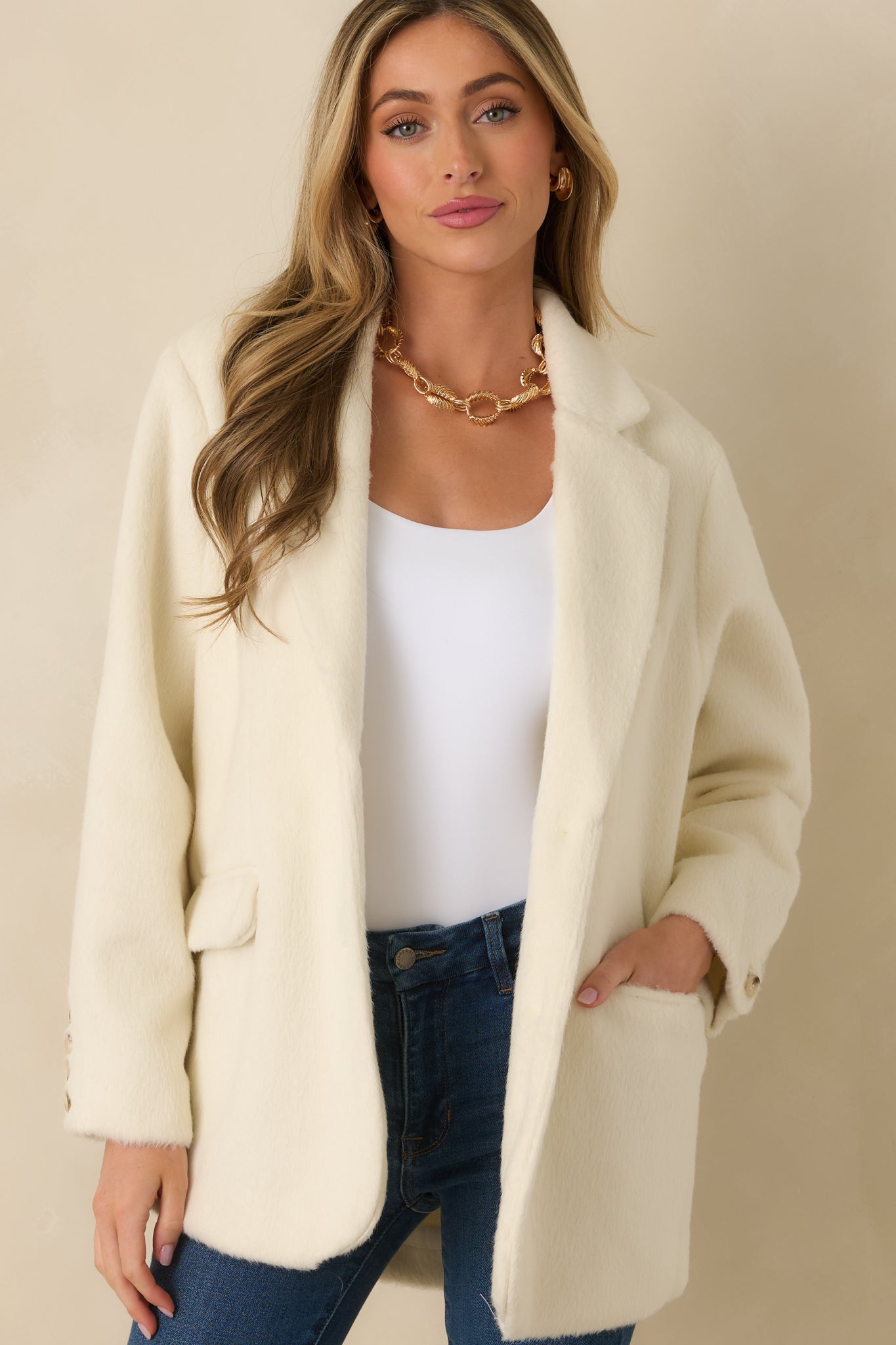 Ivory blazer front emphasizing chest welt pocket and flap pocket details.