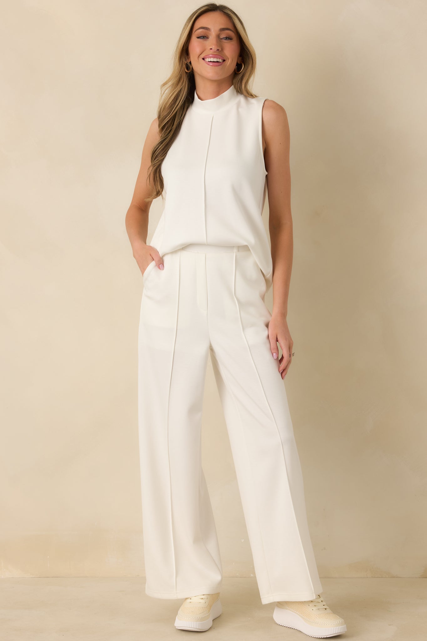 Sleeveless white tank top showcasing a soft mock neck and an effortless fit for everyday wear.