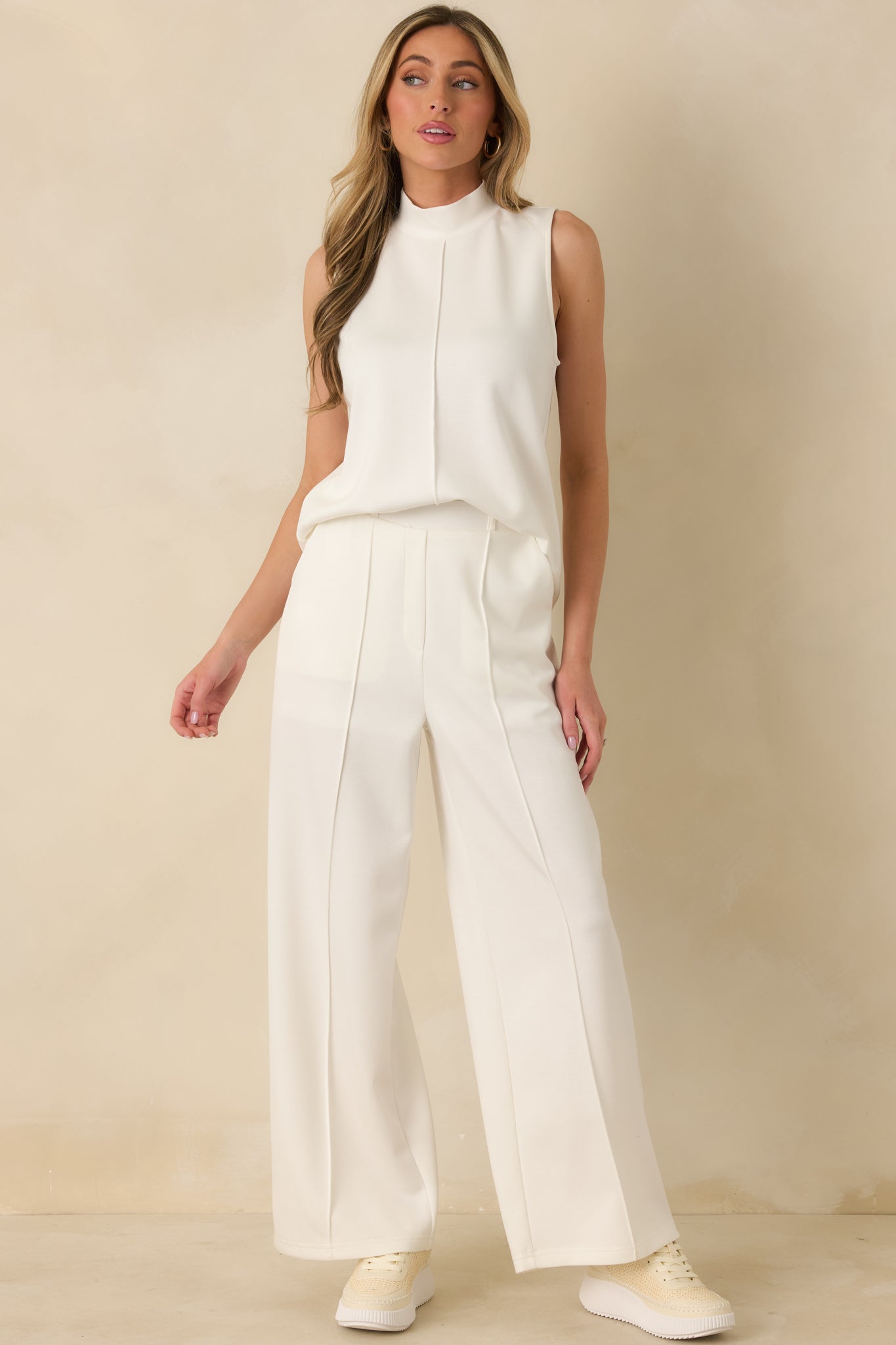 White mock-neck tank top highlighting clean lines and a straight silhouette with a polished look.