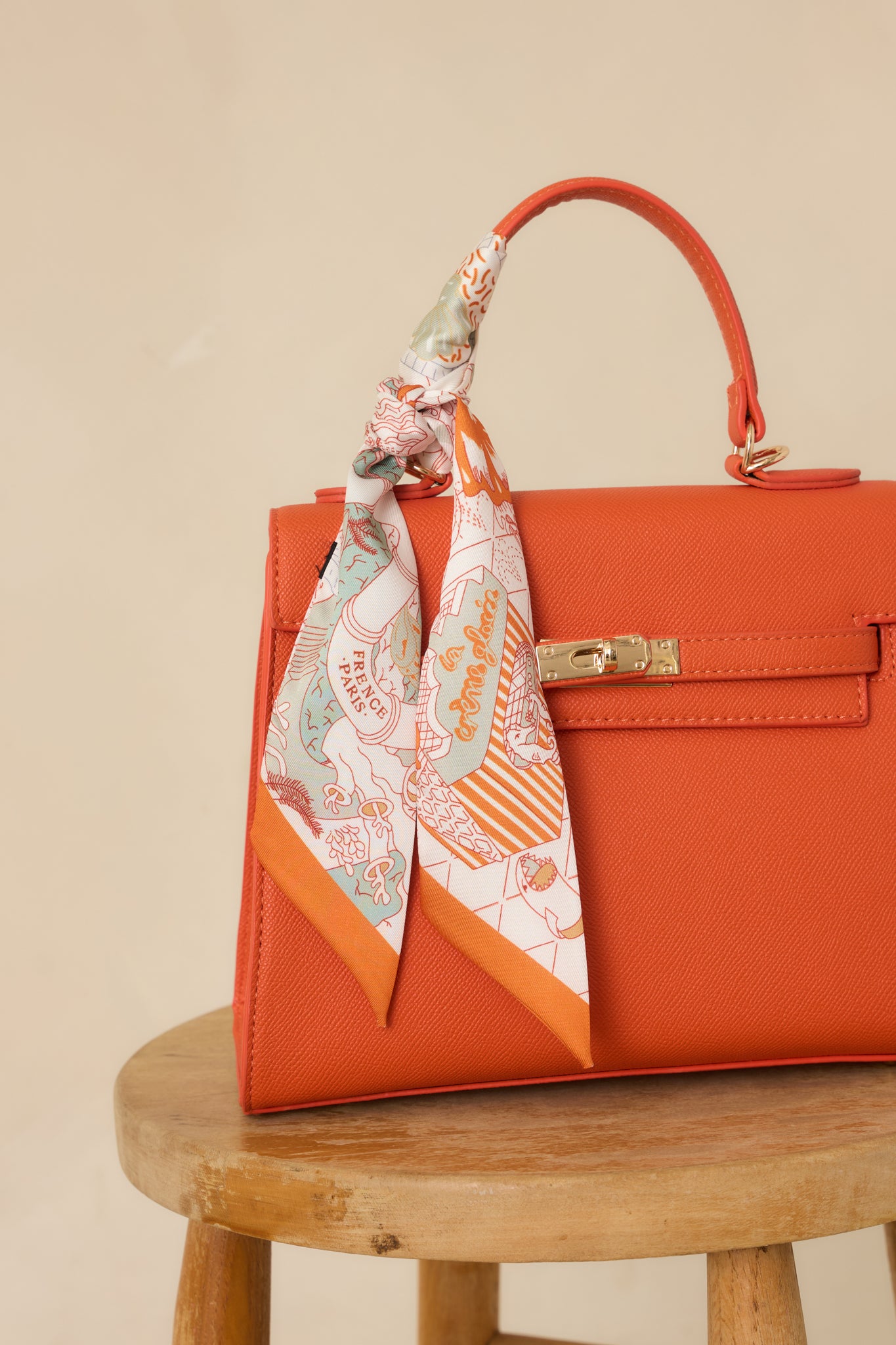 Cropped view of the orange scarf focusing on the printed seahorse motifs and narrow design.