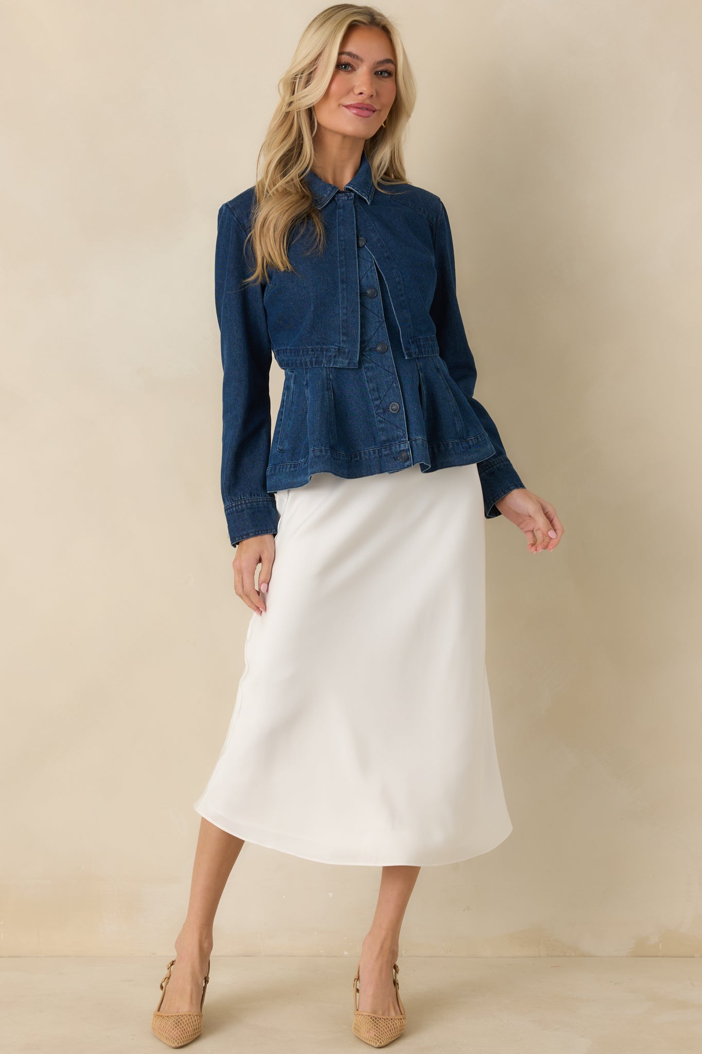 Cropped dark wash denim jacket with long sleeves, button cuffs, and classic collar detailing for a clean, structured look.