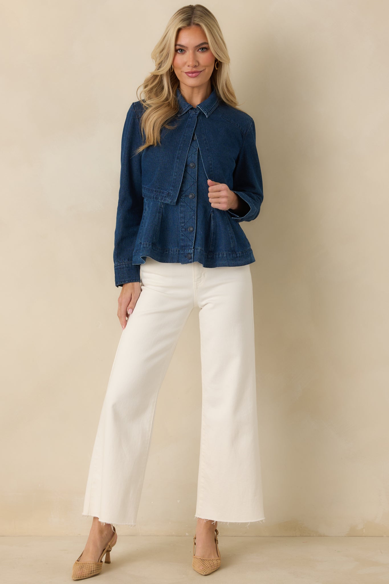 Dark wash cropped denim jacket with classic collar, long sleeves, and a clean button-front design in structured cotton fabric.