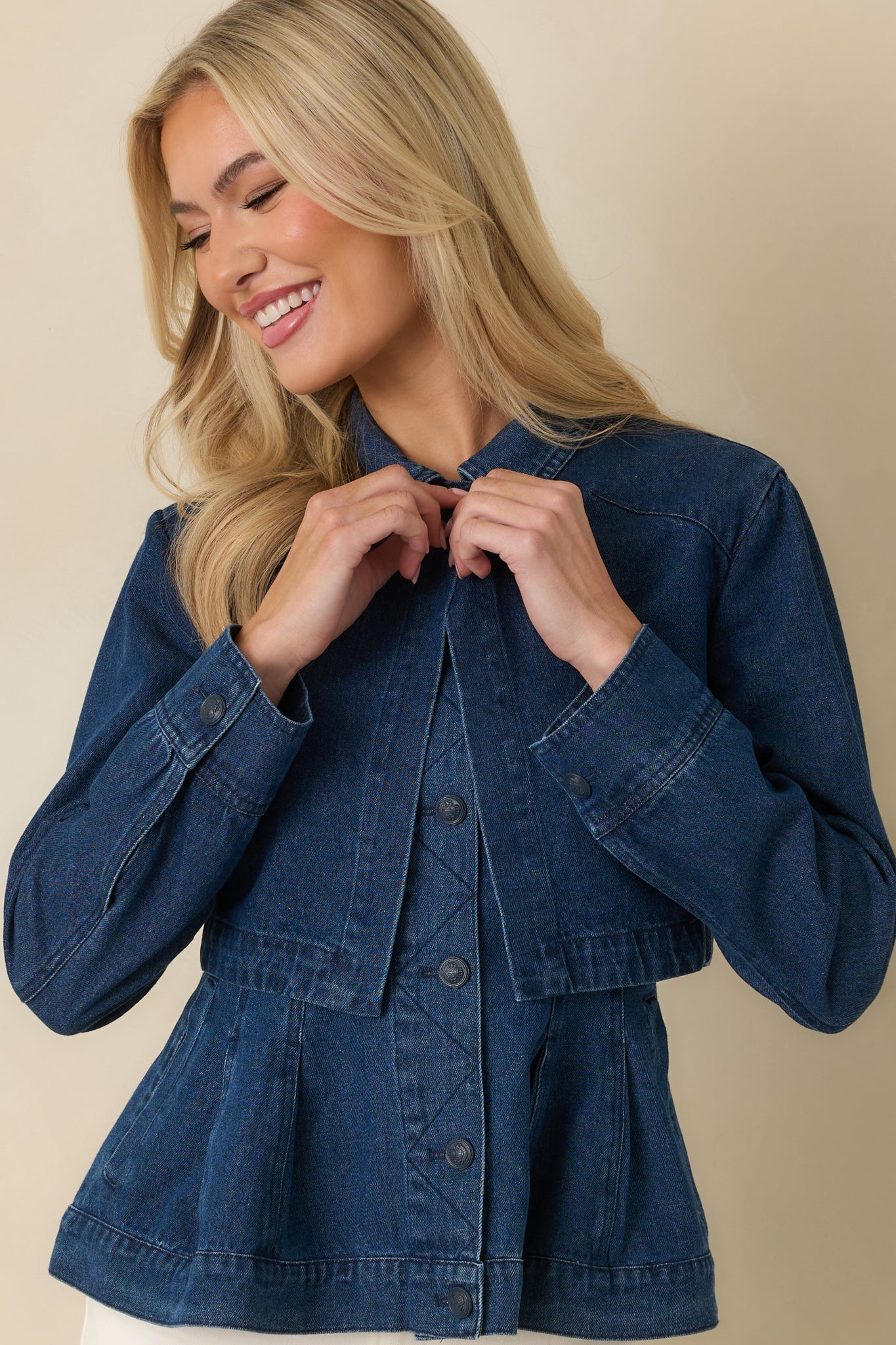 Dark wash cotton denim jacket focusing on the front button closure and crisp collar shape in a tailored cropped fit.