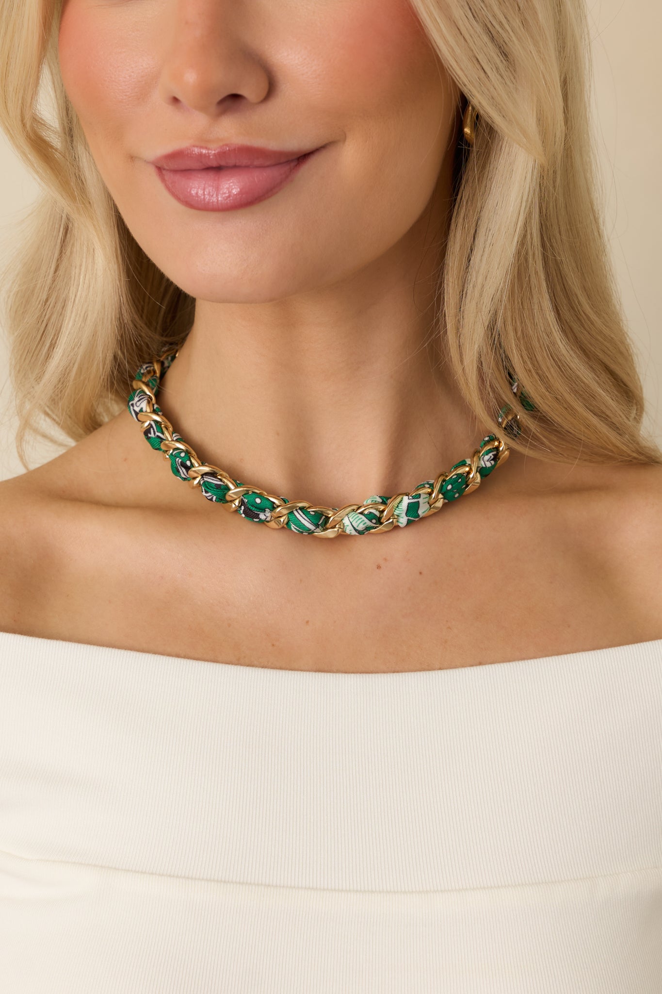 Cropped front view of gold-tone chain necklace woven with green multi-patterned scarf fabric in a structured choker silhouette.