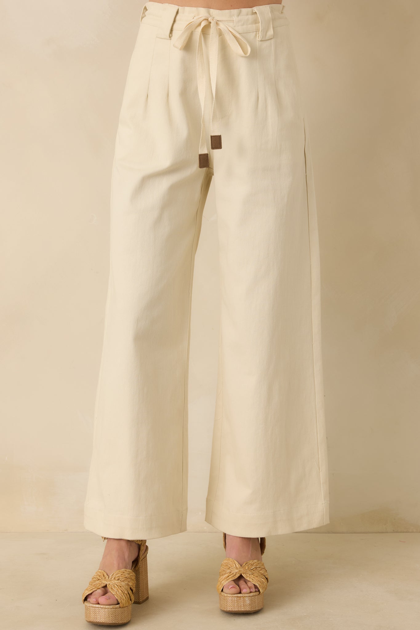 Cropped front view emphasizing the adjustable tie belt and high-rise waist of the wide-leg pants.