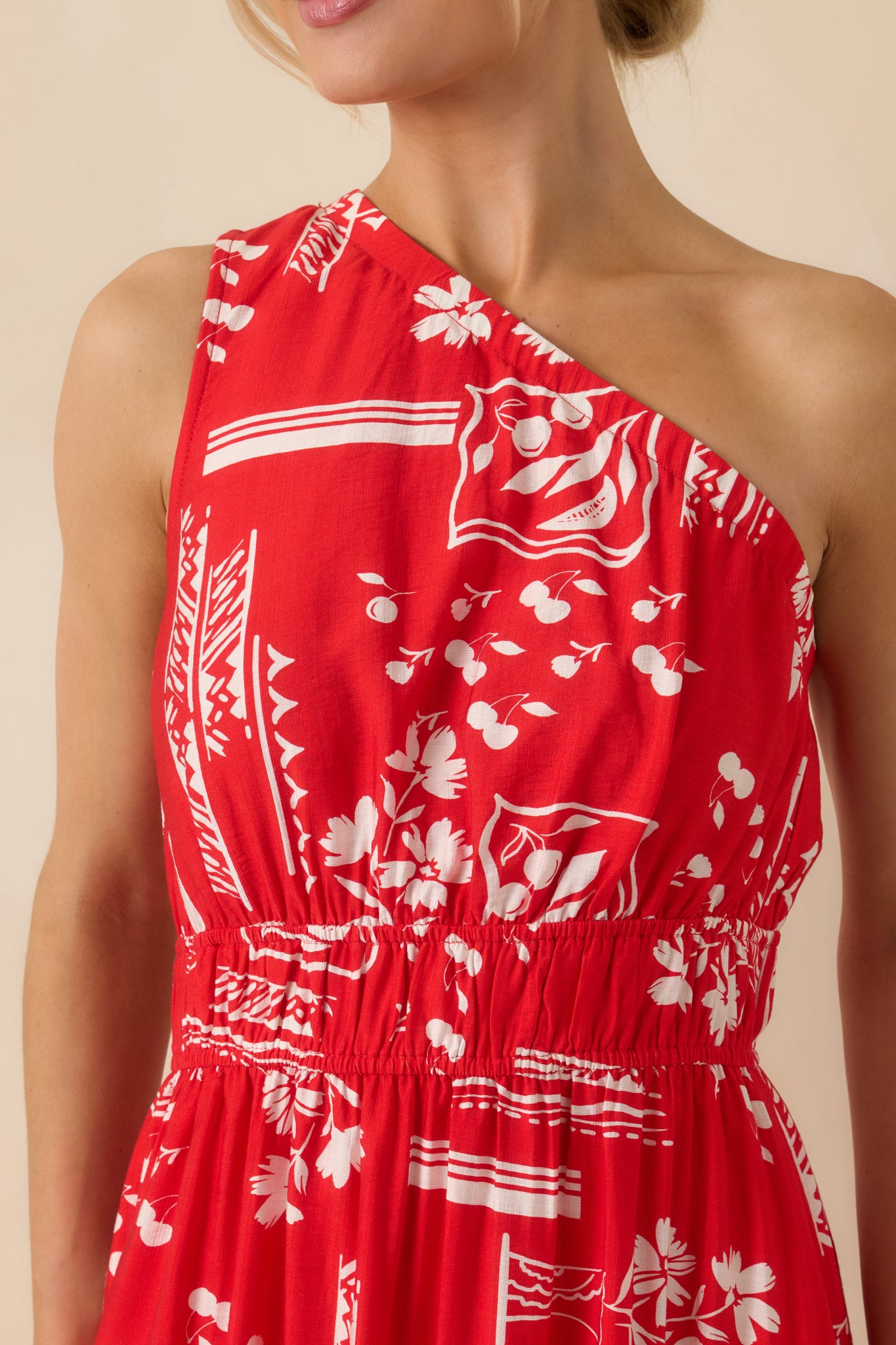 Close-up of red maxi dress showing geometric floral print, fabric texture, and elastic waist detail.