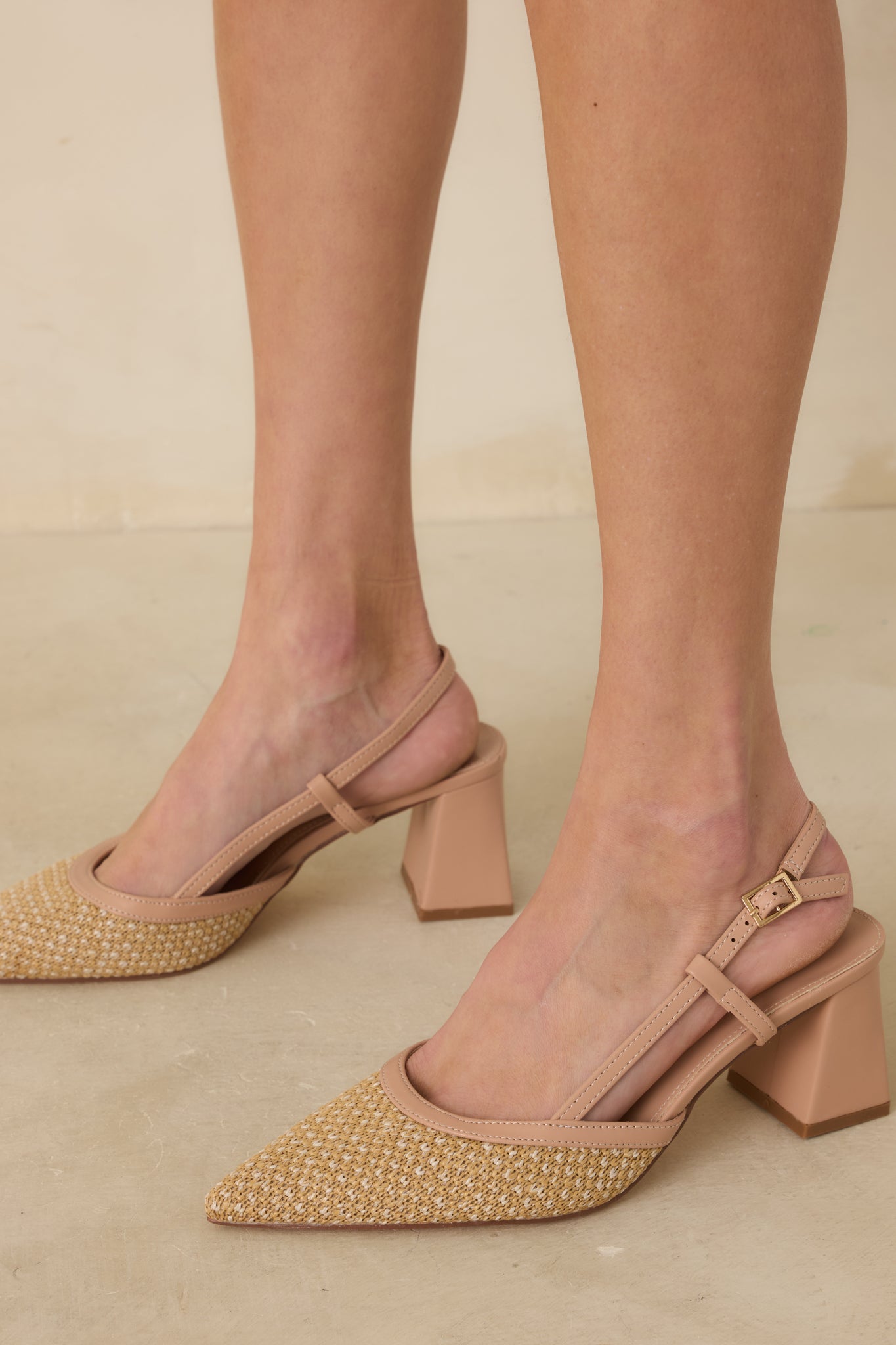 Detailed cropped shot of the beige heels showcasing the contrast between the woven toe and solid block heel.