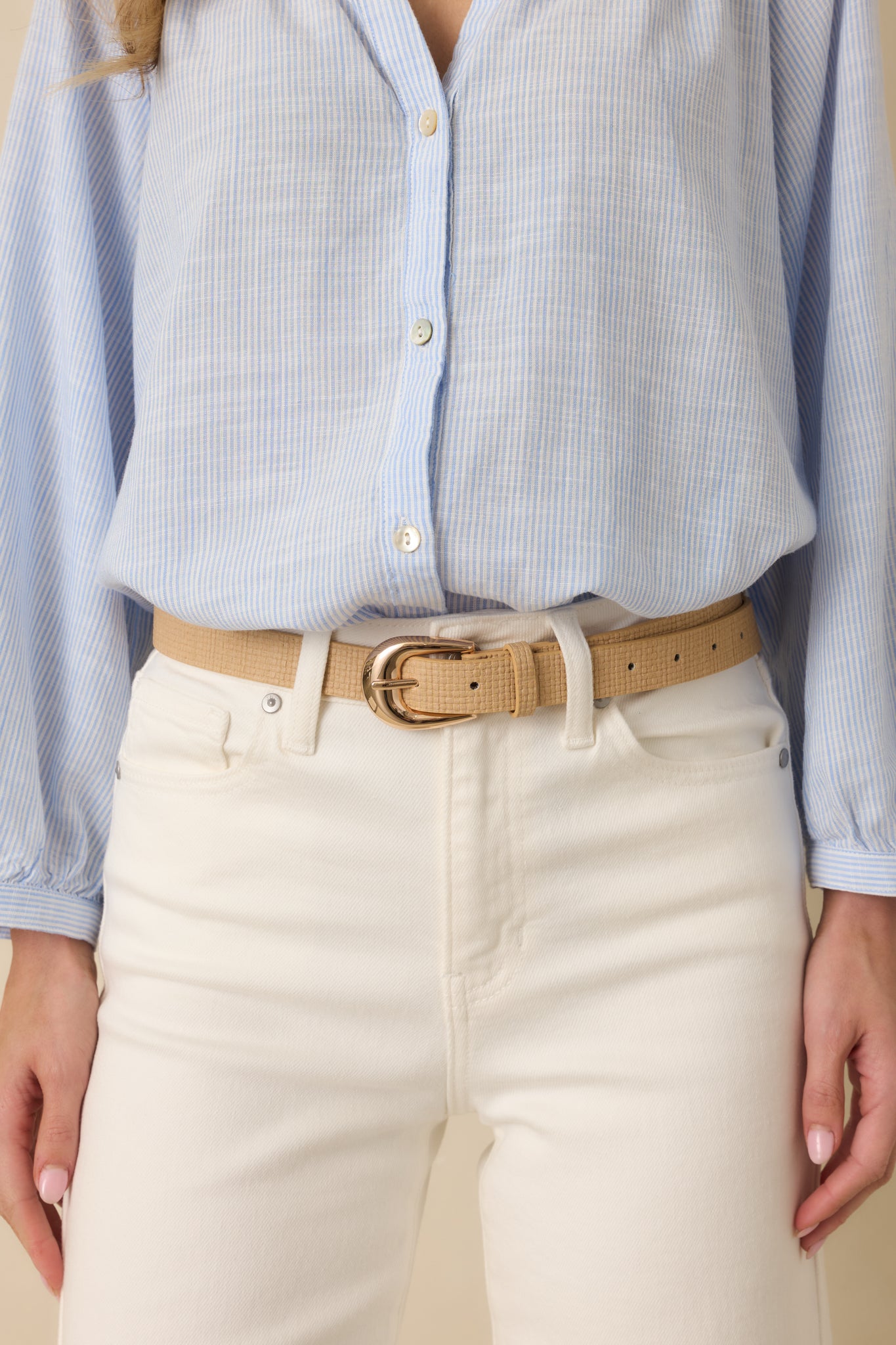Front view cropped of the tan faux leather belt showcasing woven-texture finish and gold-tone buckle.