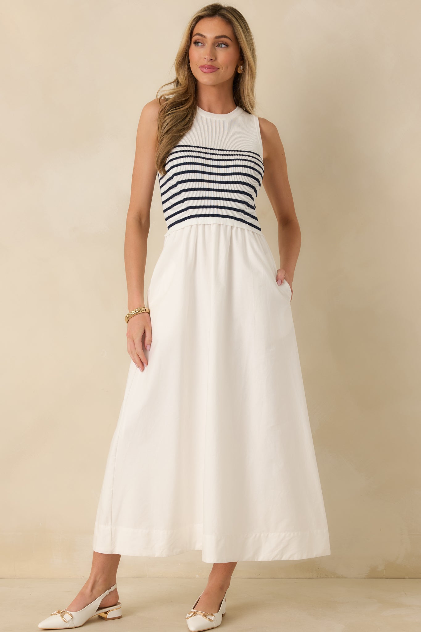 White stripe dress with structured fit, round neckline, and practical front-access pockets.