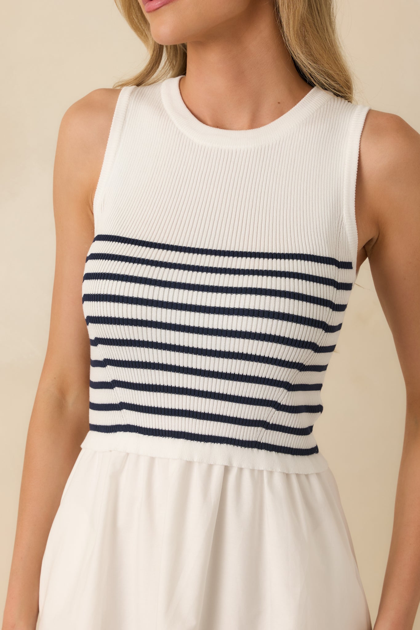 Textured white stripe fabric highlighting round neckline and pocket openings on fitted bodice.