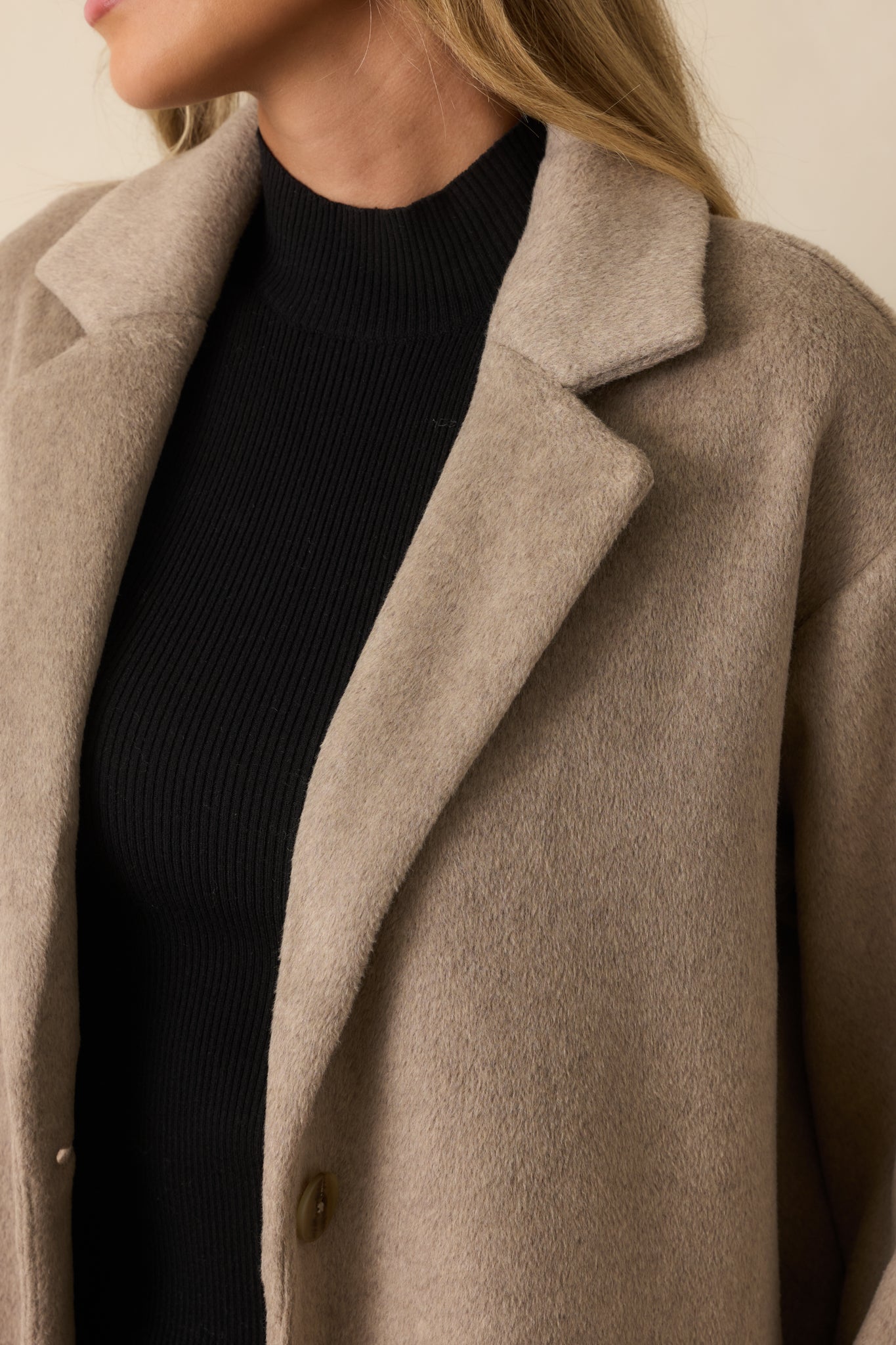 Close-up detail showing the brushed luxe fabric texture, notched lapel, and front button.