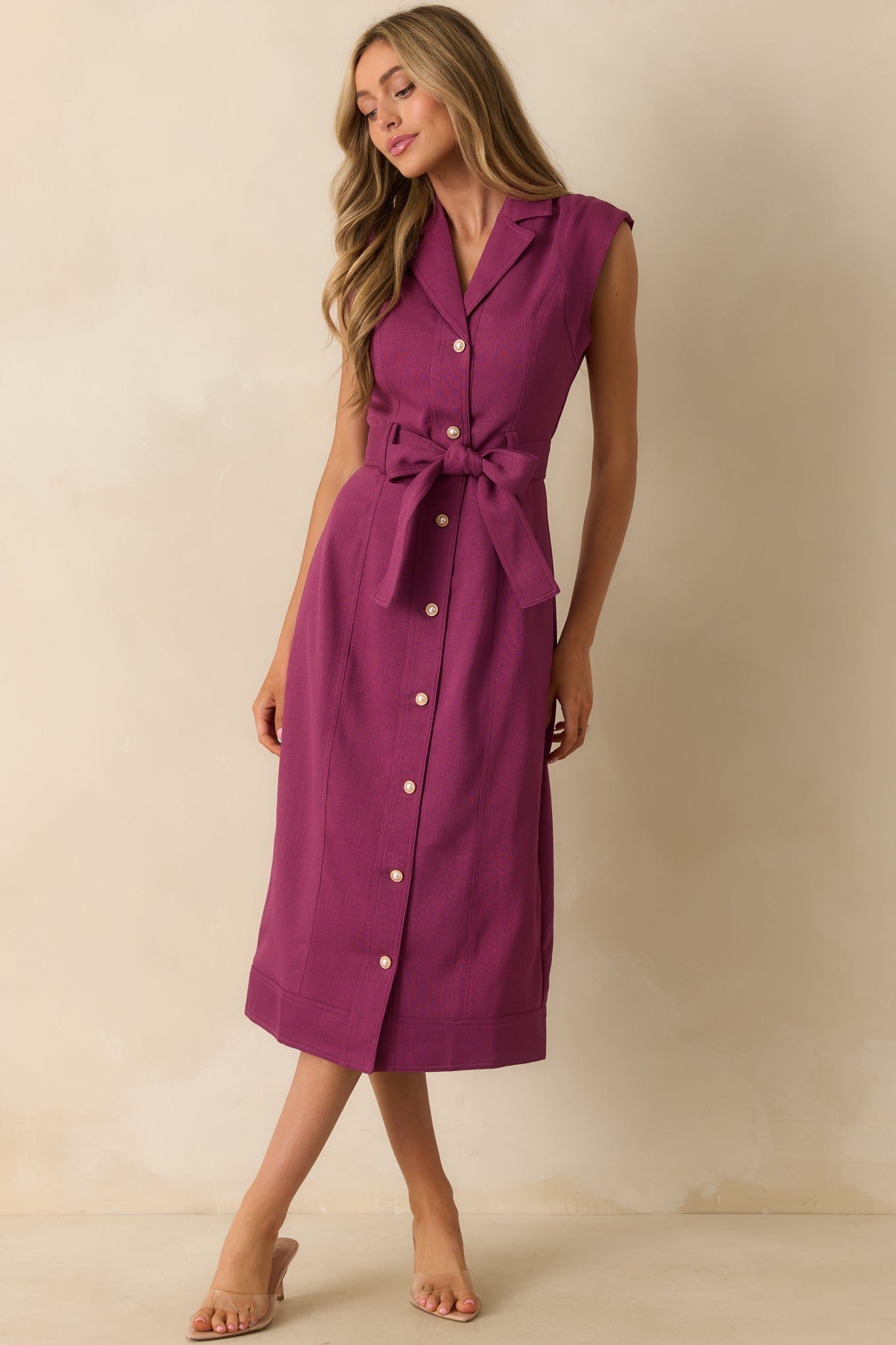 Plum dress featuring a collared neckline and refined button-down front with a belted waist.