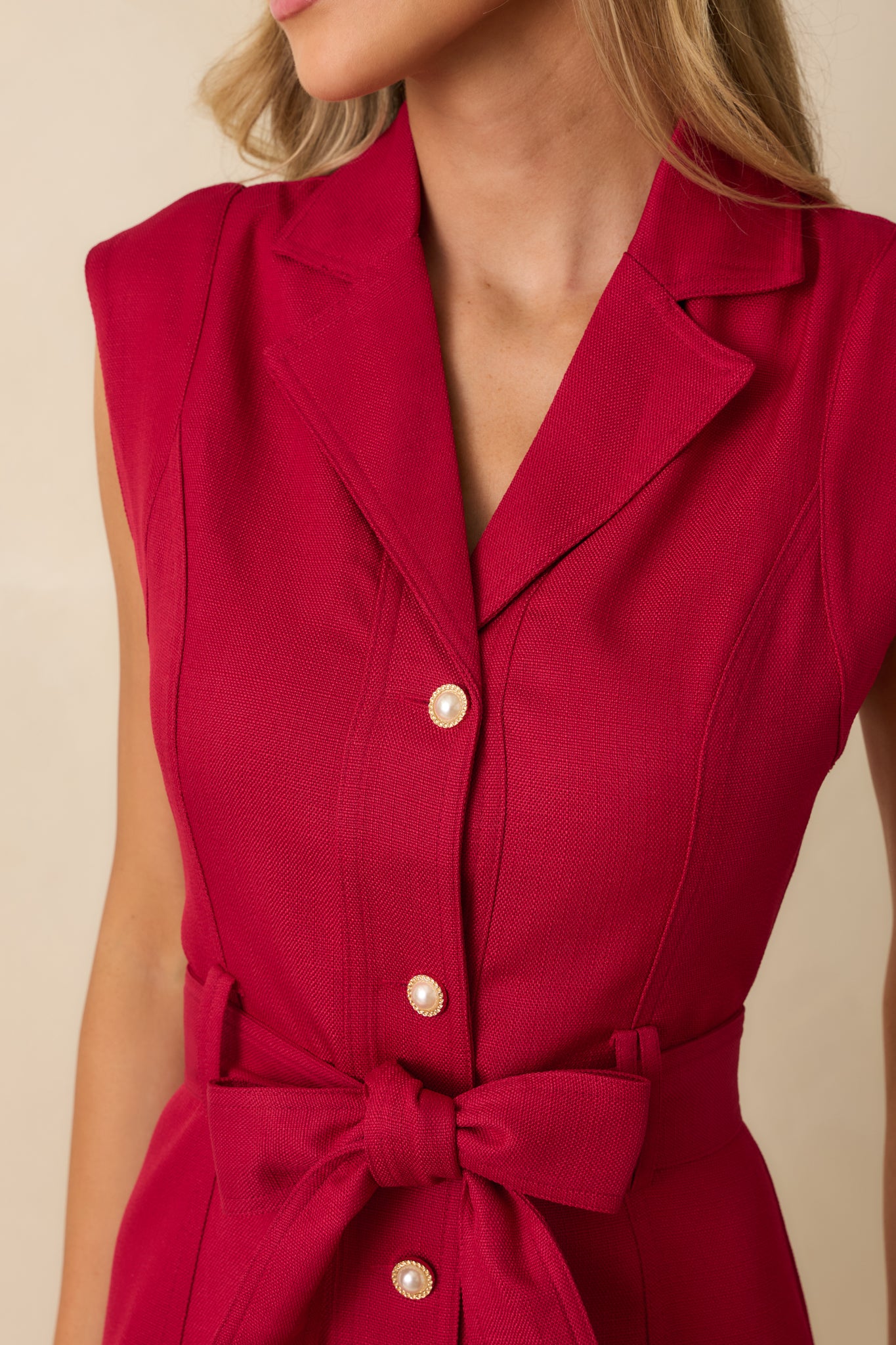 Close-up of the red fabric and button-front detailing showing the texture and rich color.